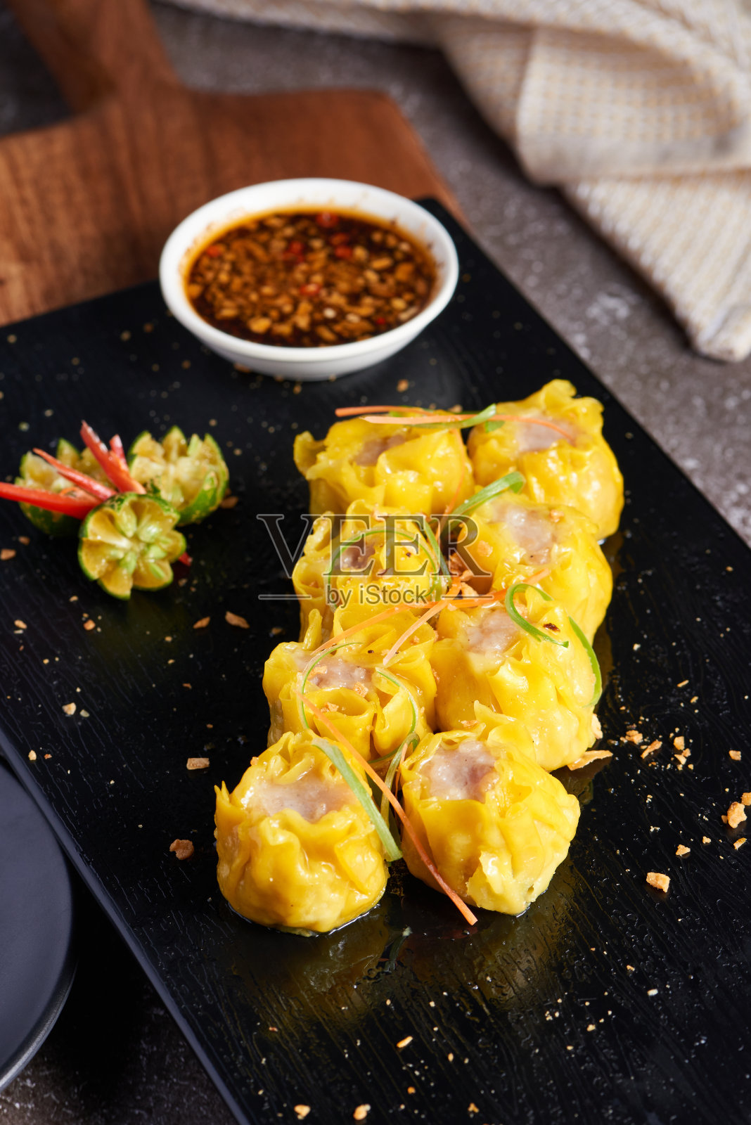 垂直拍摄的一盘酱油在一个黑色的盘子照片摄影图片