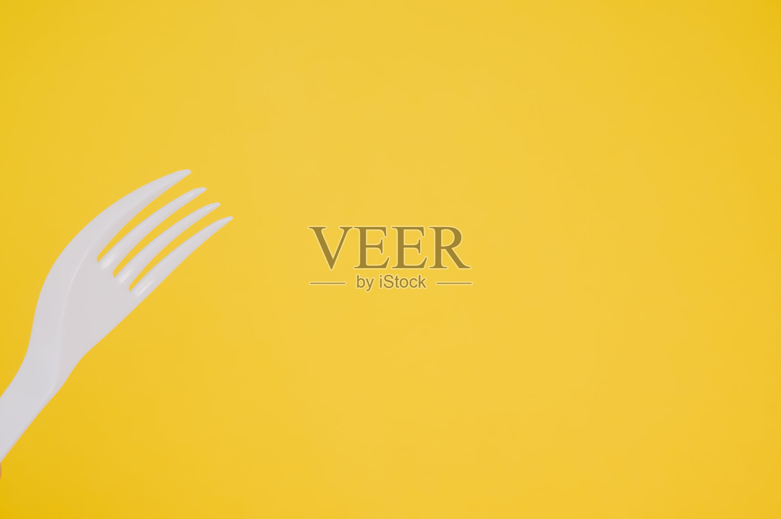 黄色背景下的塑料叉子特写镜头照片摄影图片