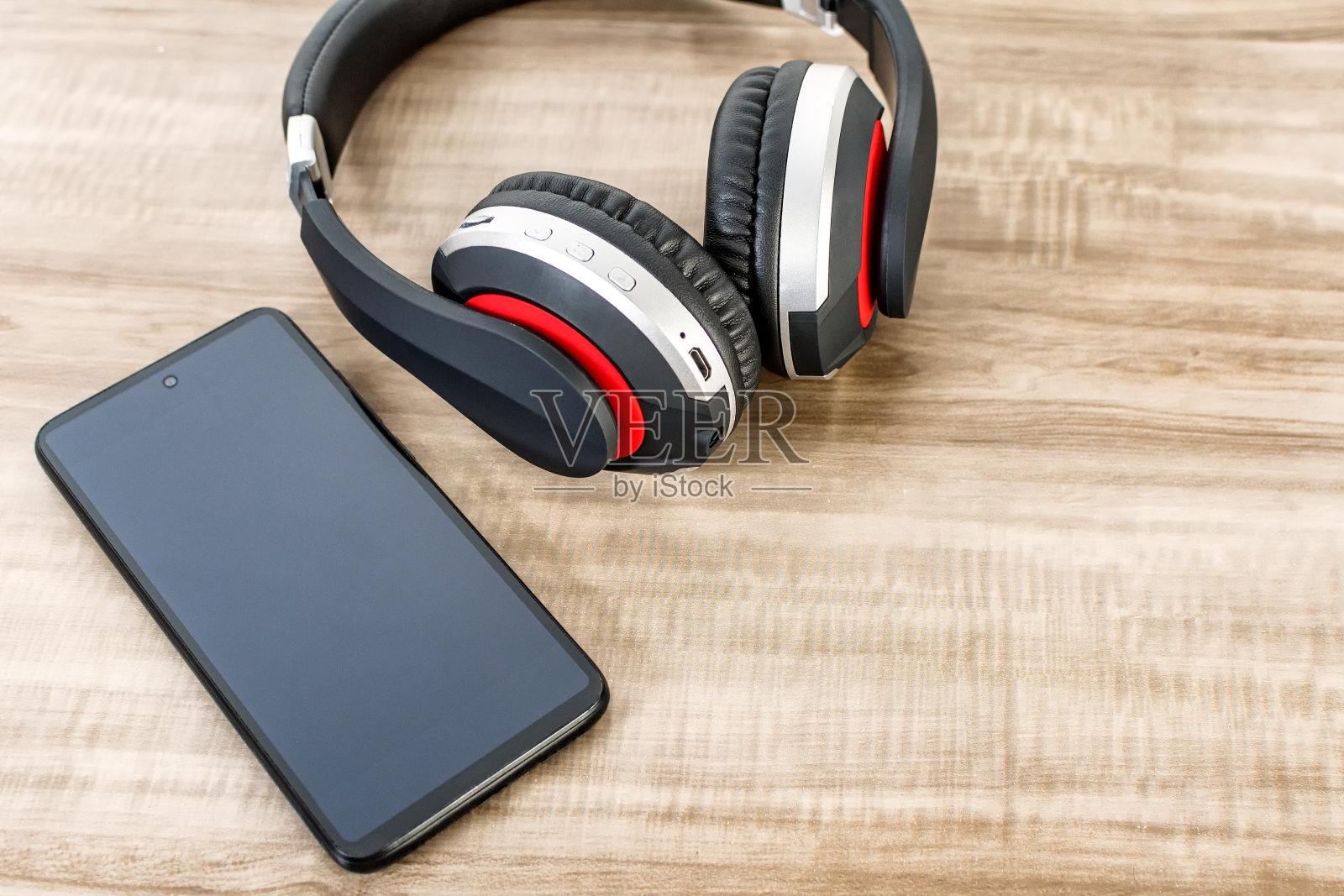 木桌上的手机和无线耳机的俯视图照片摄影图片