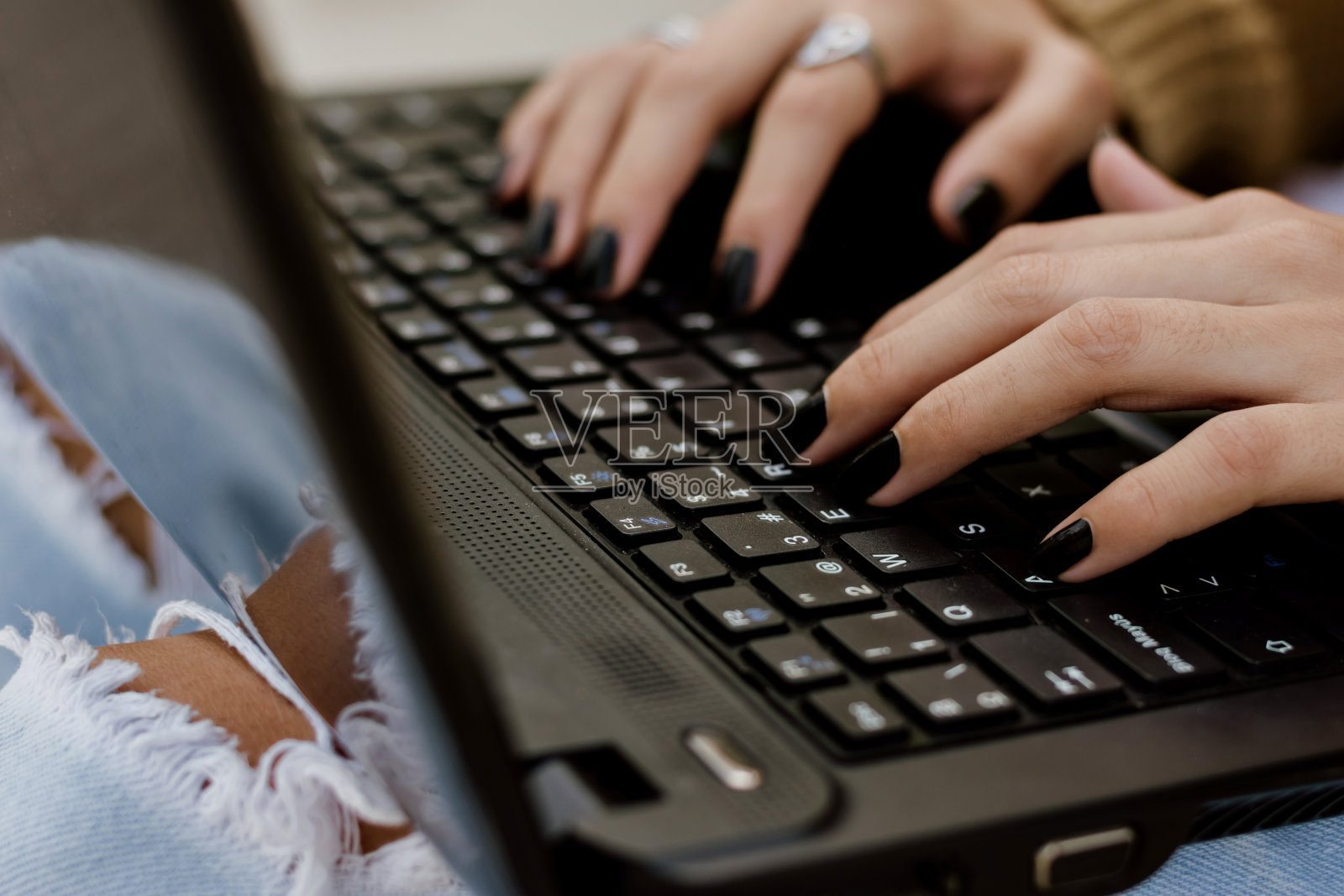 女性在黑色笔记本上打字的特写镜头照片摄影图片