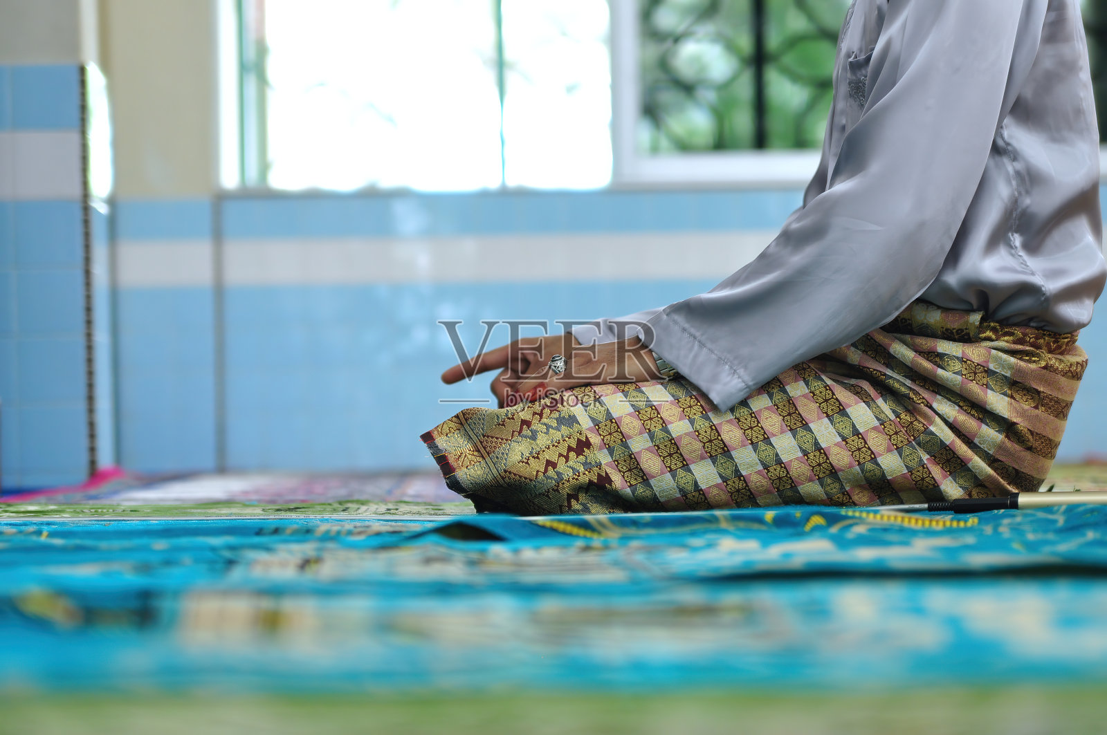 一名穿着迷人服饰的穆斯林男子正在清真寺里祈祷照片摄影图片