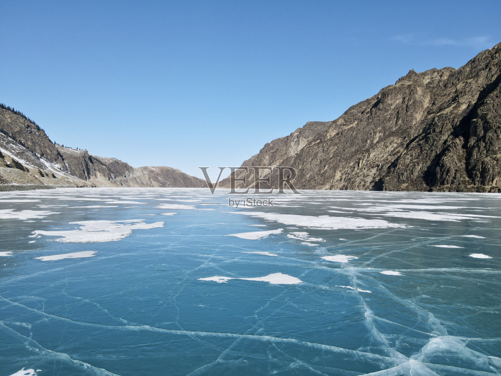 雪后的结冰湖和山脉照片摄影图片