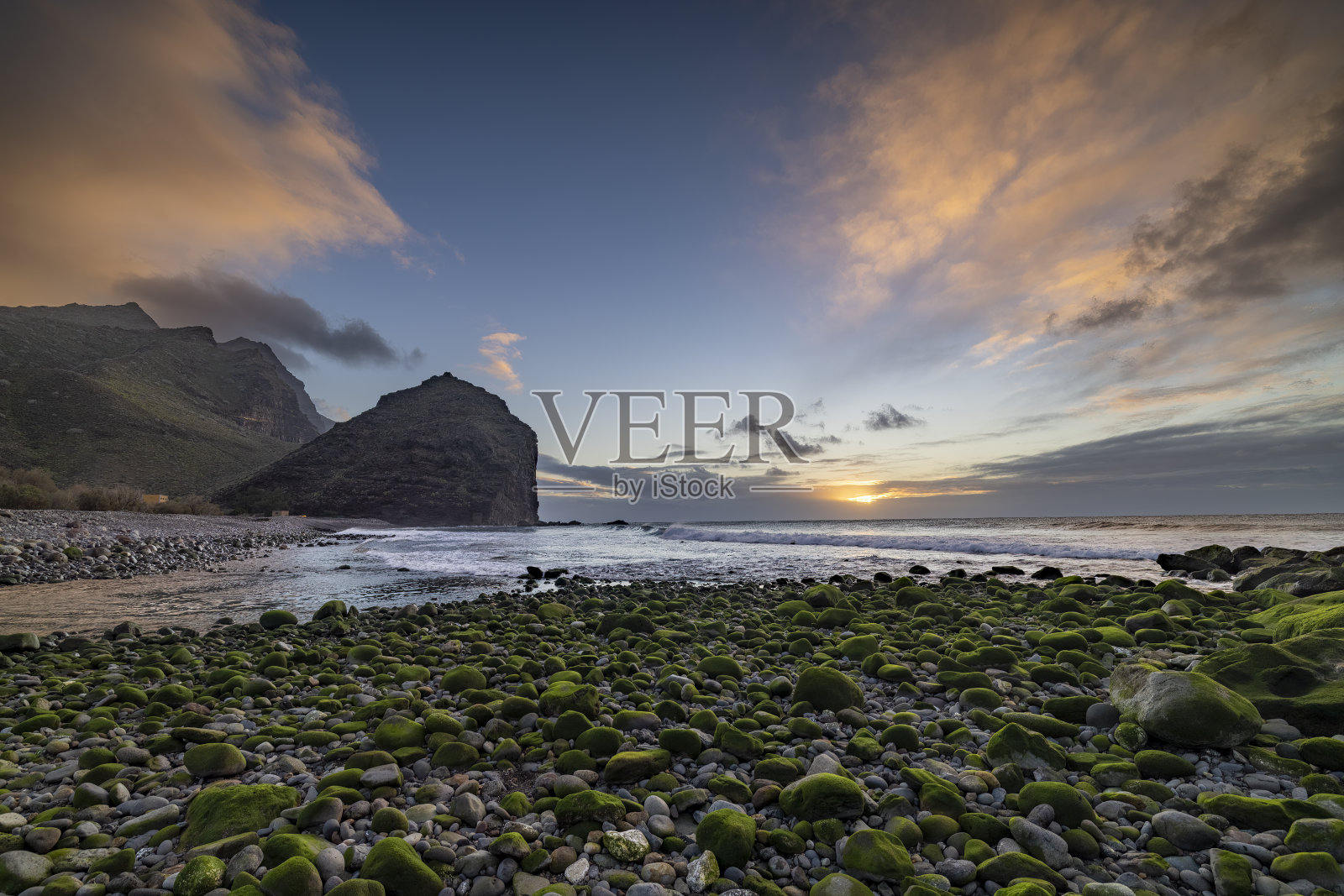 陆地和海洋上的日落:岩石海滩的景色照片摄影图片