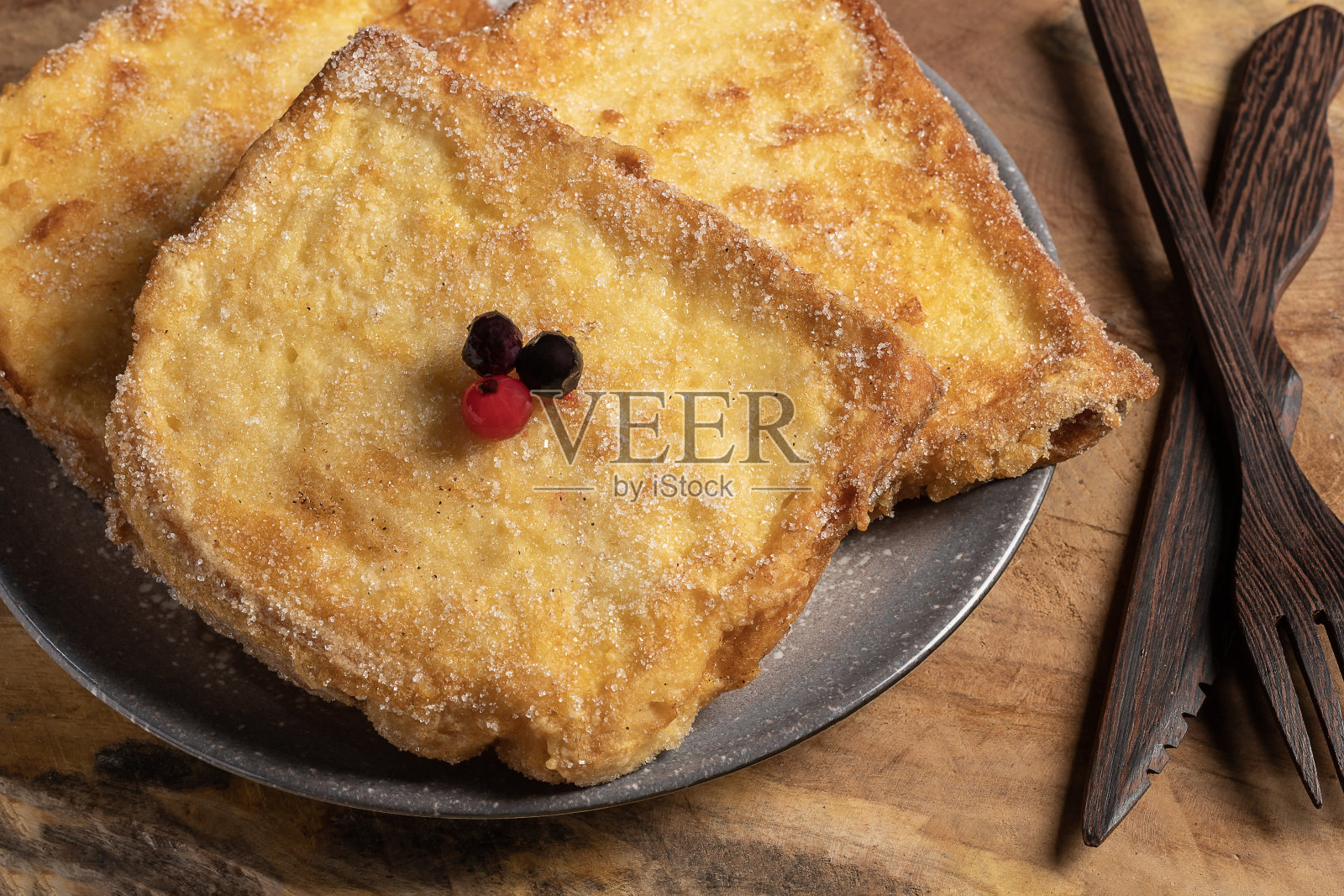 (Torrijas)在牛奶中浸泡的油炸面包，加入香草、肉桂、柠檬和鸡蛋，背景是木制的。典型的复活节甜点。传统节日美食的概念。照片摄影图片