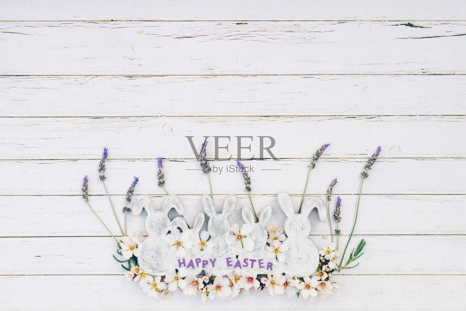 平坦的白色和灰色的木制复古复活节兔子形状与薰衣草和杏仁花和字母复活节快乐的白色木制背景与复制空间照片摄影图片