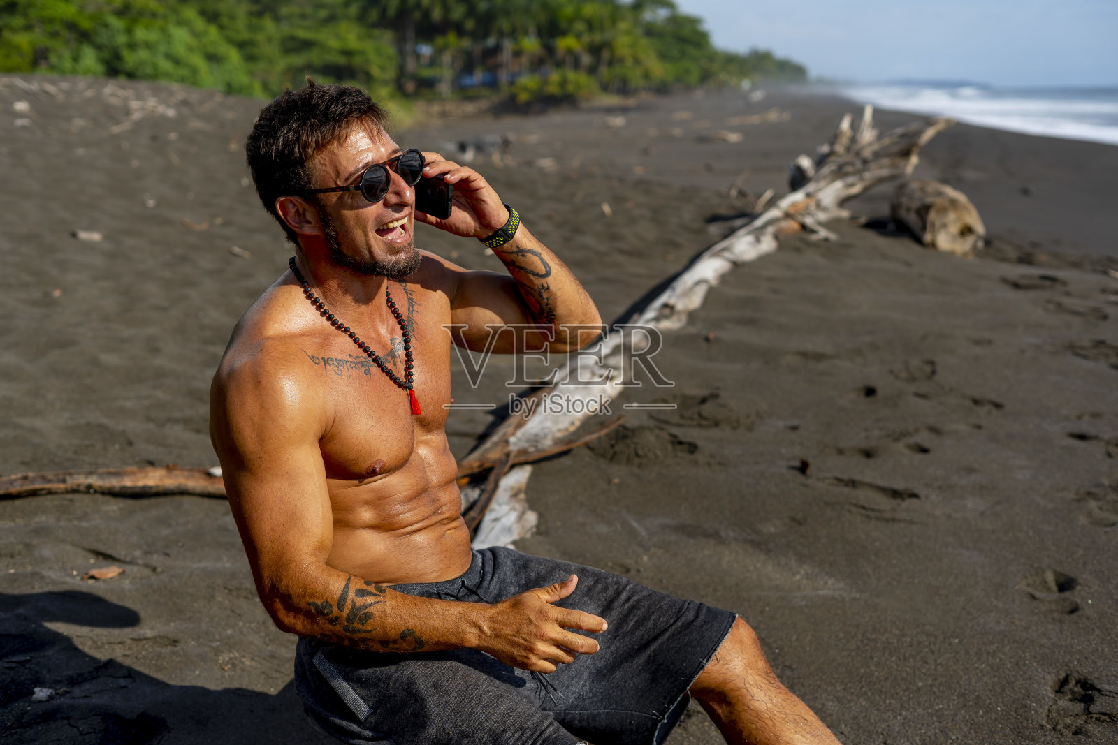 海滩上有个年轻人在打电话照片摄影图片