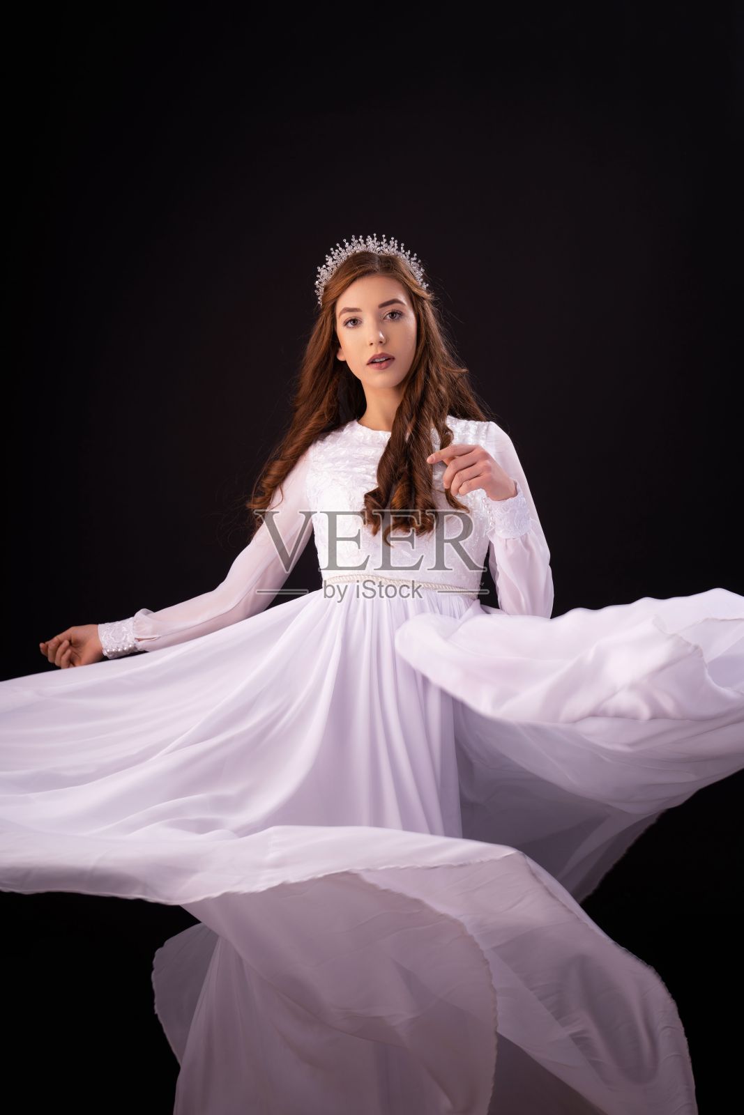 一个漂亮的白人年轻女孩在一个黑色的背景婚纱垂直拍摄。照片摄影图片