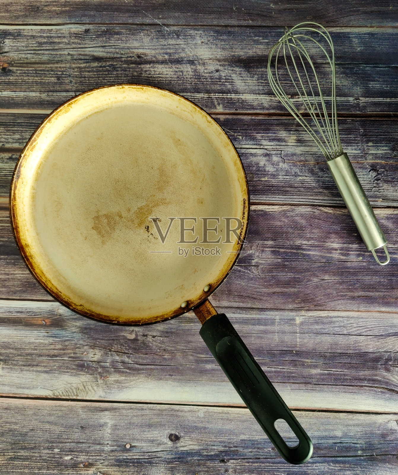 平底锅和打蛋器，用于在木桌上搅拌照片摄影图片