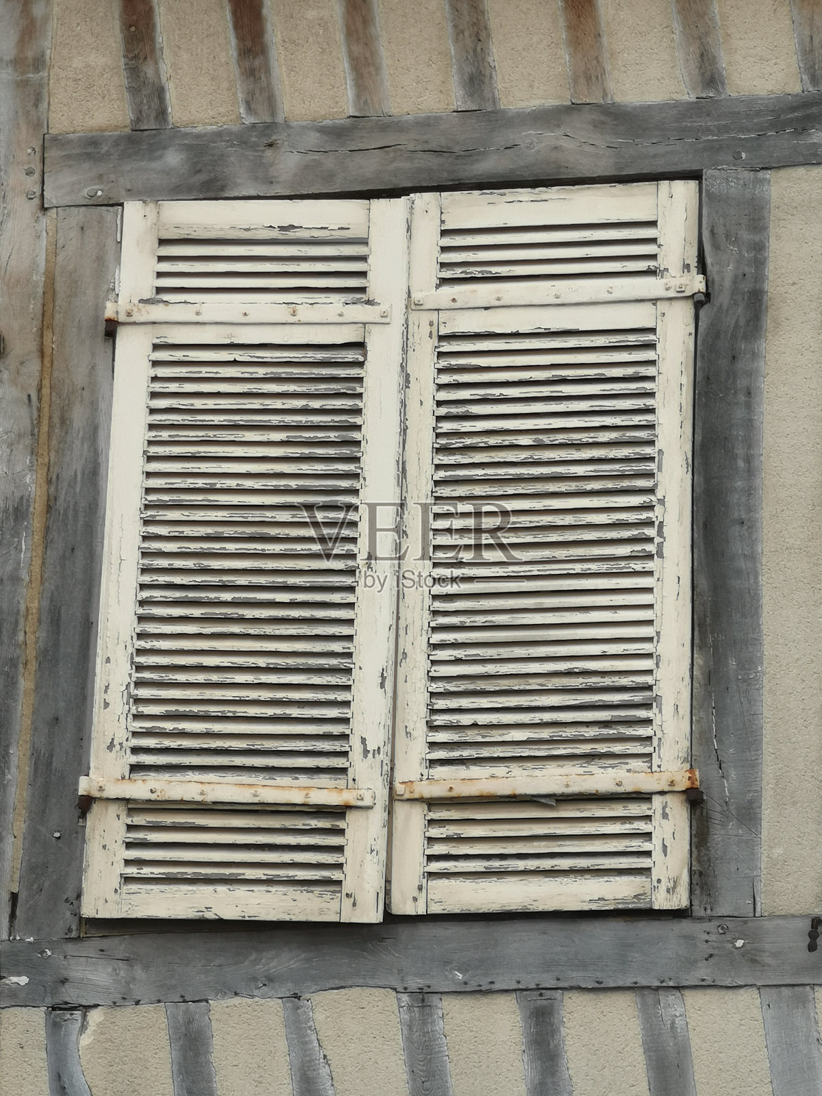 Old weathered shutters on a house in Normandië, France.照片摄影图片