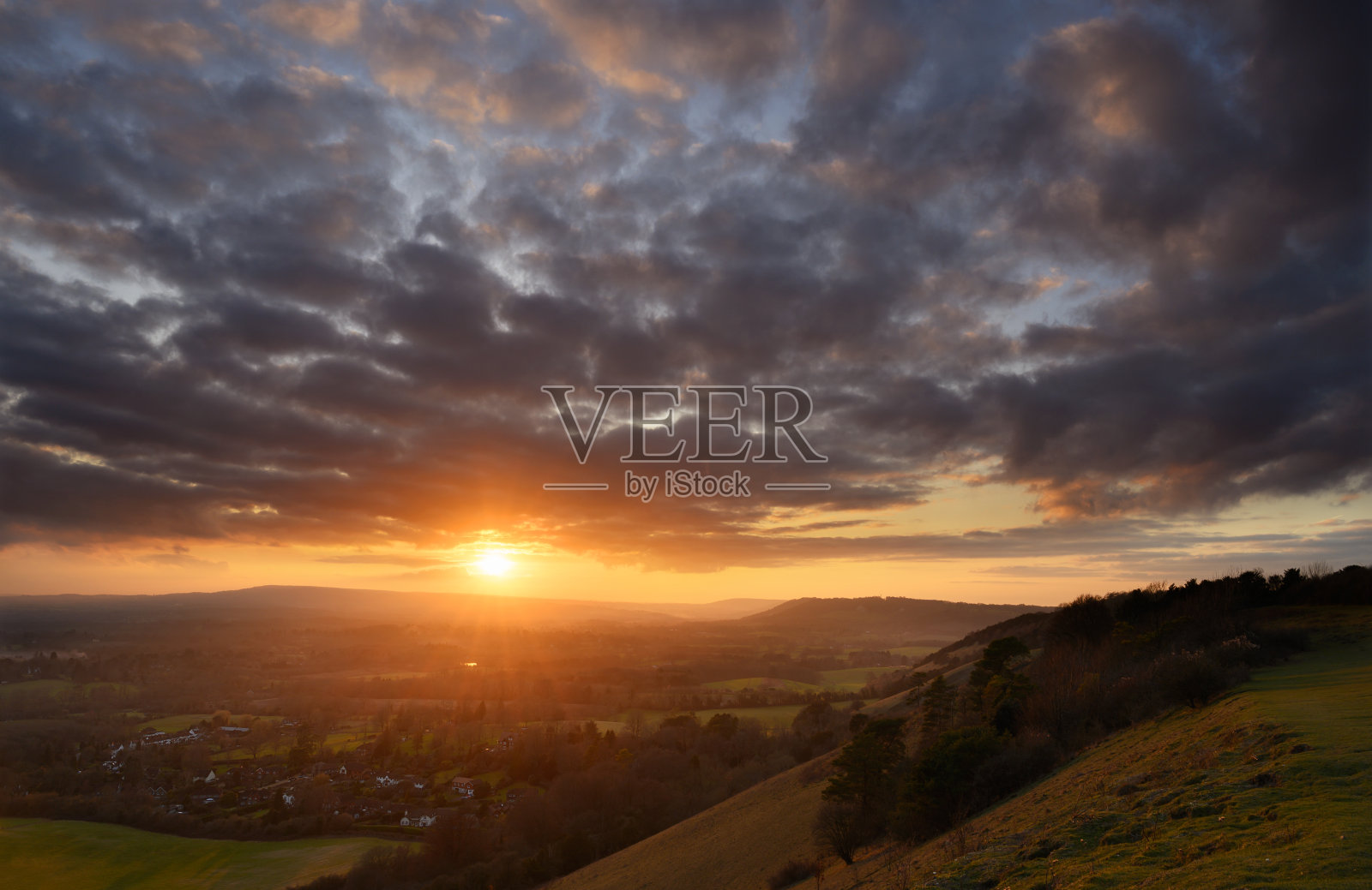 在英国萨里郡的北部丘陵上，落日余辉熠熠照片摄影图片