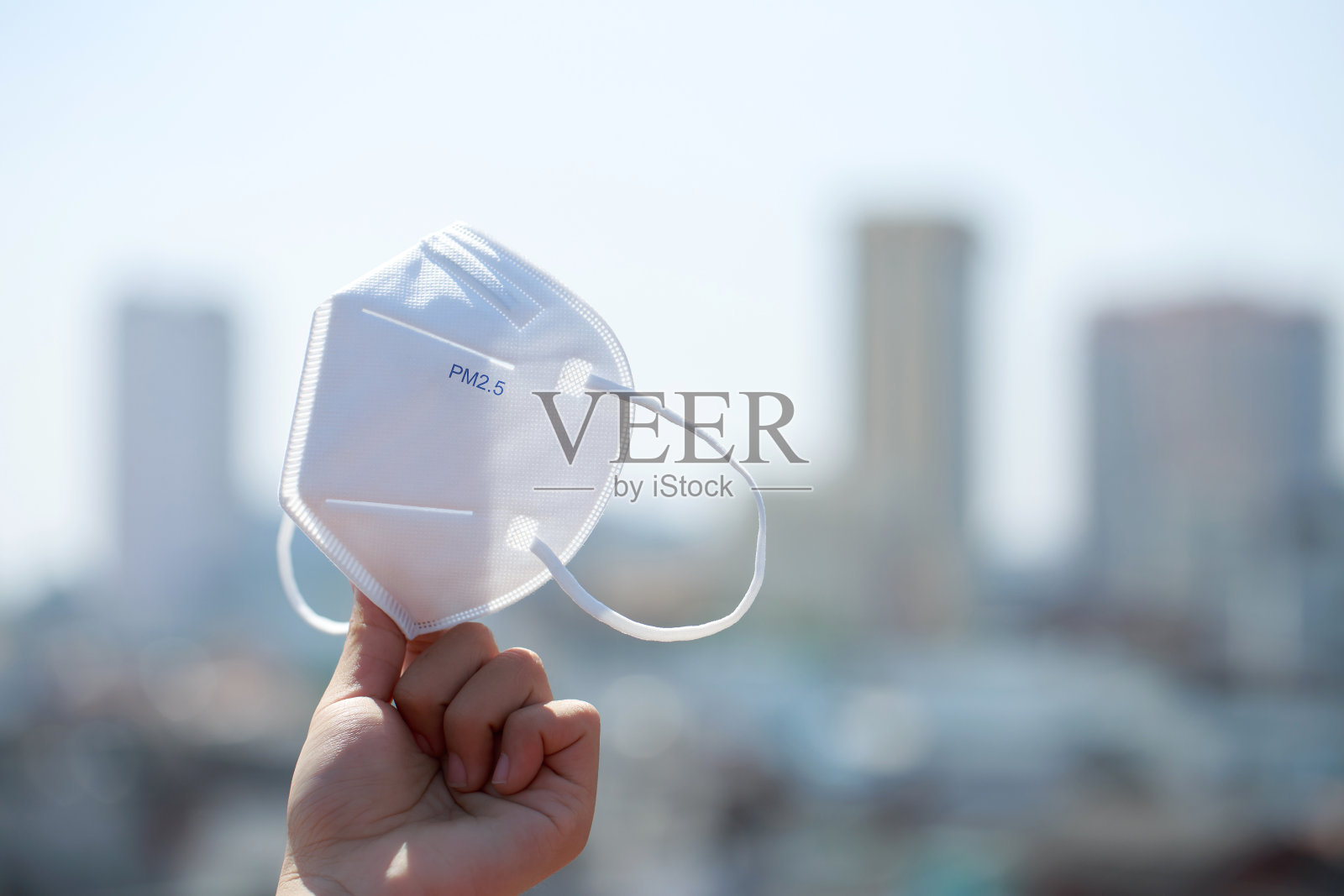 手提式pm2.5防护口罩，预防污染、病毒、流感和冠状病毒(Covid-19)。保护pm 2.5。空气口罩。医学的面具。有毒的雾霾笼罩着城市。照片摄影图片