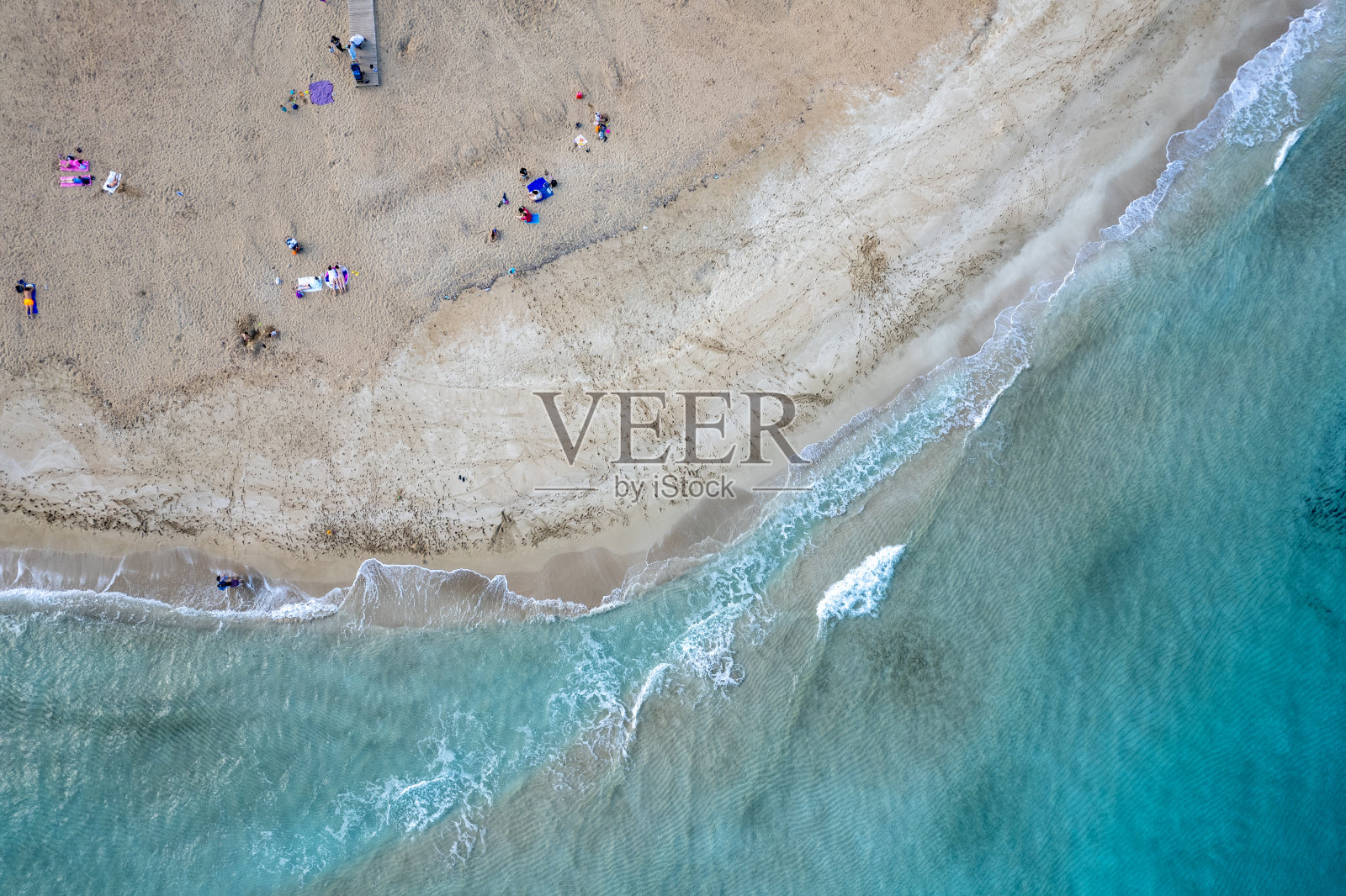 无人机拍摄的冬季人们在沙滩上放松的照片。雾树湾海滩，度假胜地照片摄影图片