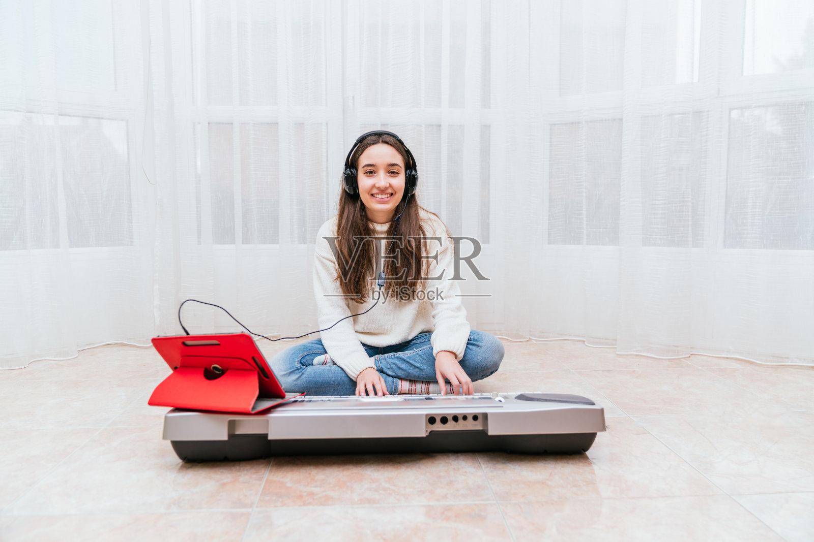 一名西班牙女子一边用平板电脑弹奏数码钢琴照片摄影图片