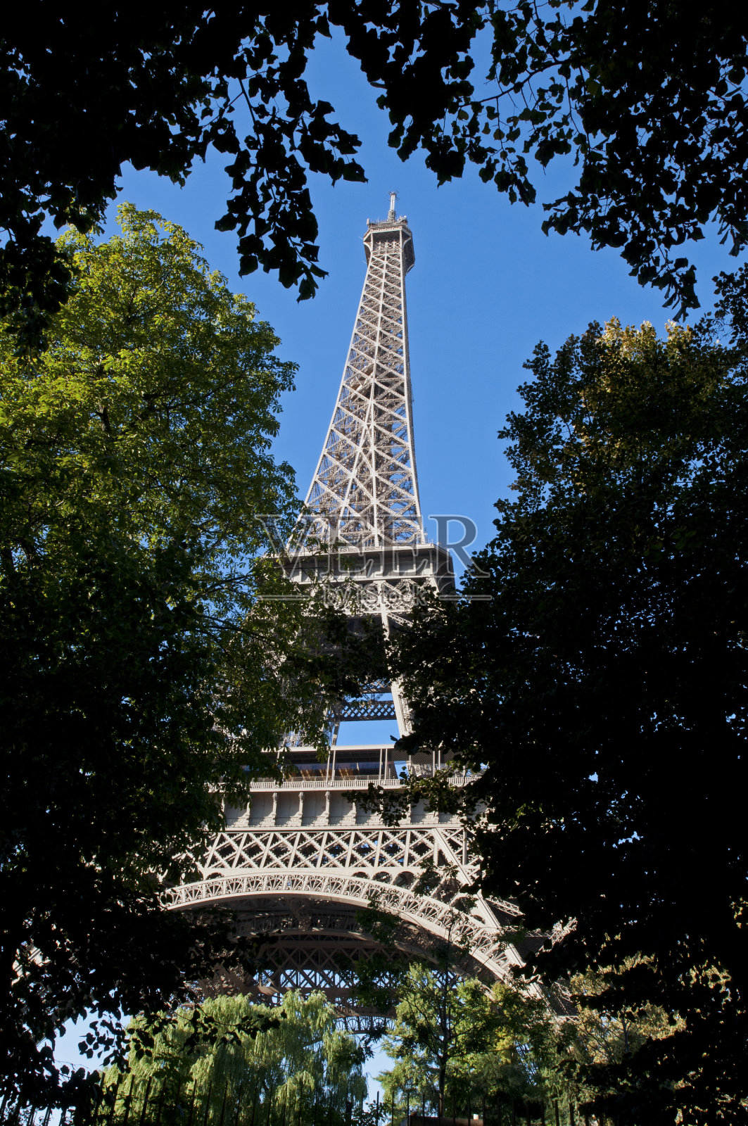 巴黎公园的埃菲尔铁塔周围环绕着树木照片摄影图片