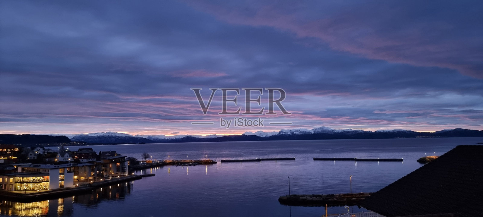 航拍平静的大海，背景是紫色夜空下的群山照片摄影图片