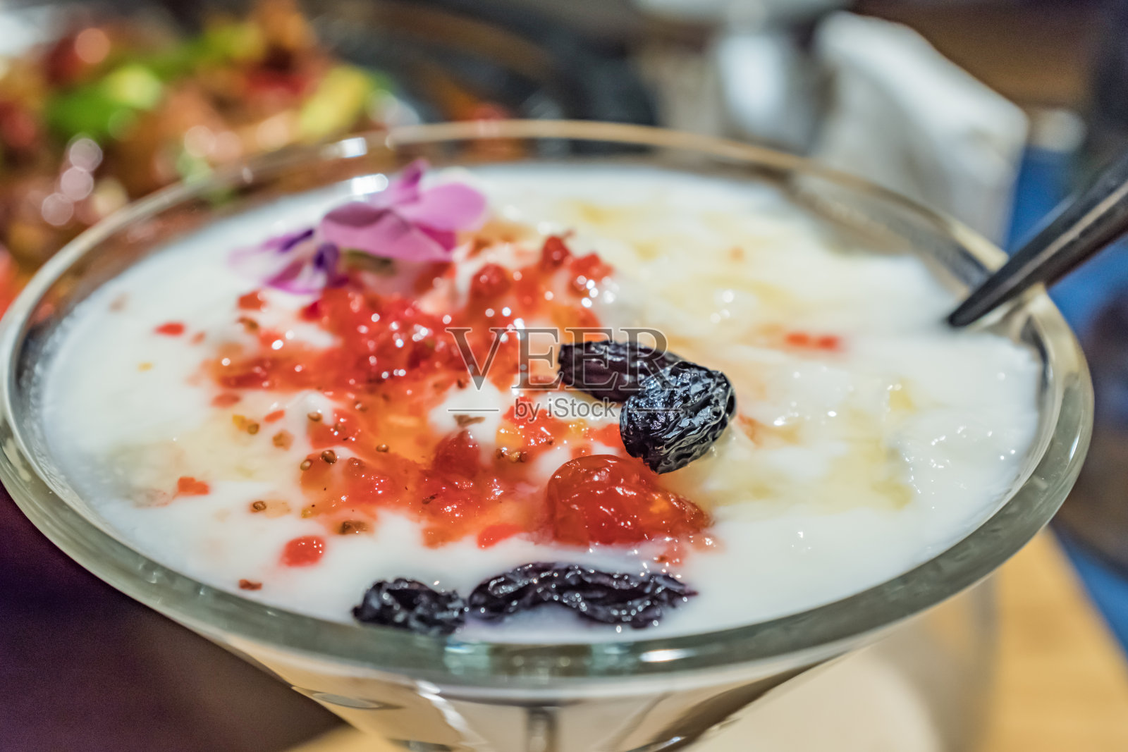 用鸡尾酒杯盛的酸奶，加葡萄干和花瓣照片摄影图片