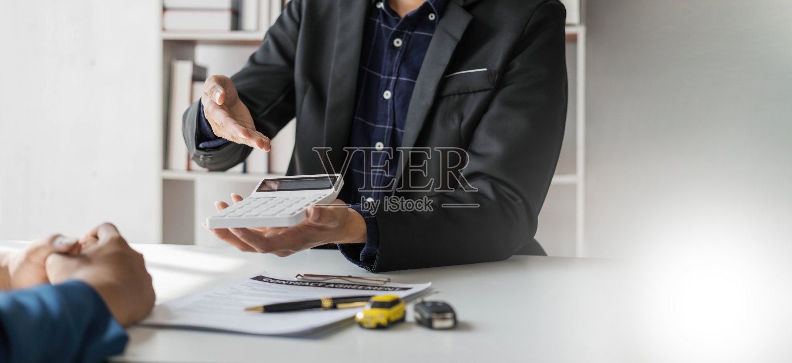 汽车租赁和保险概念，年轻的销售人员在与客户签订协议合同后，将汽车交付给客户是关键。照片摄影图片