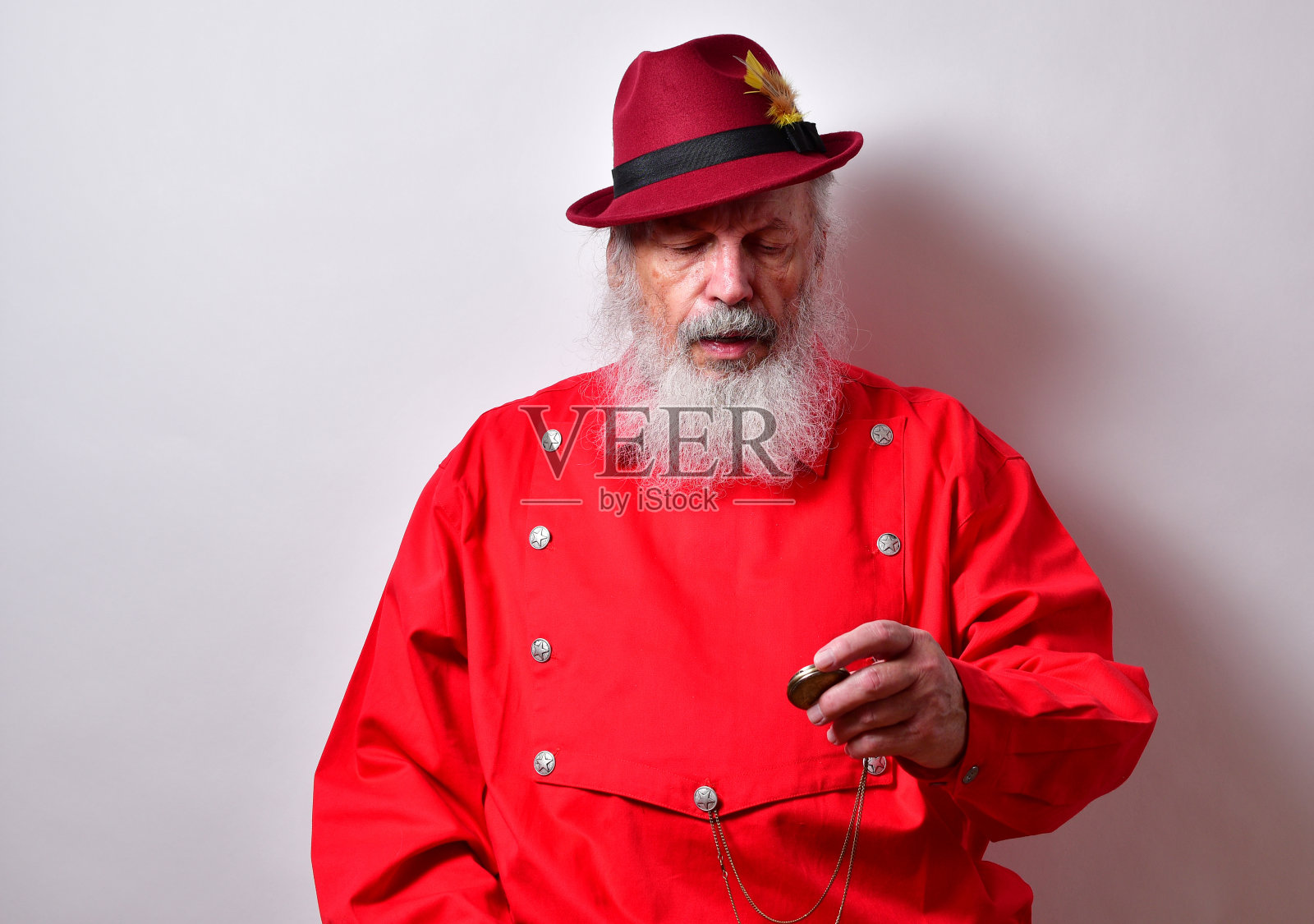 退休的美国男性，红色的西部围嘴衬衫看着他的怀表照片摄影图片