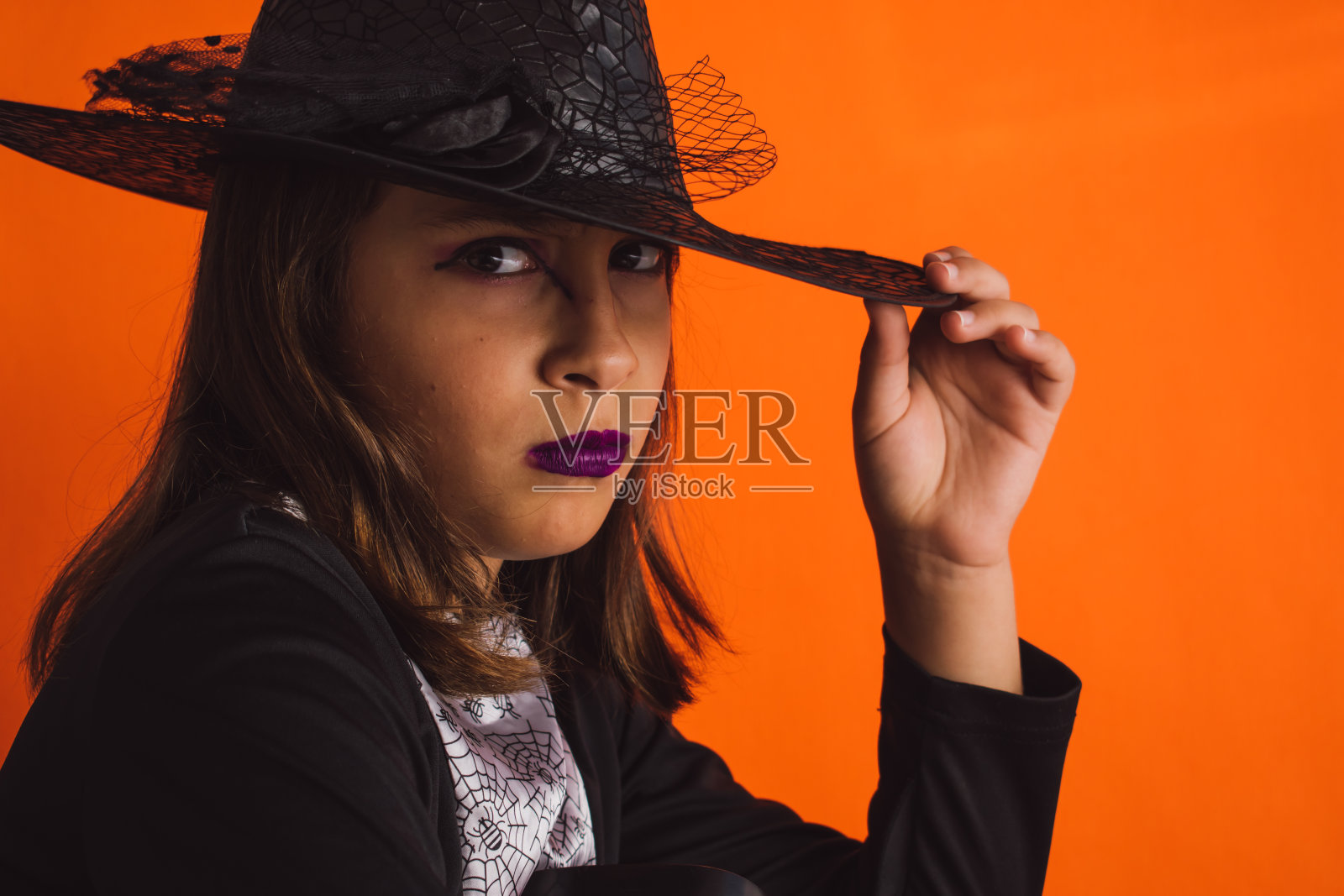 白人女孩子穿着橙色背景的女巫服装照片摄影图片