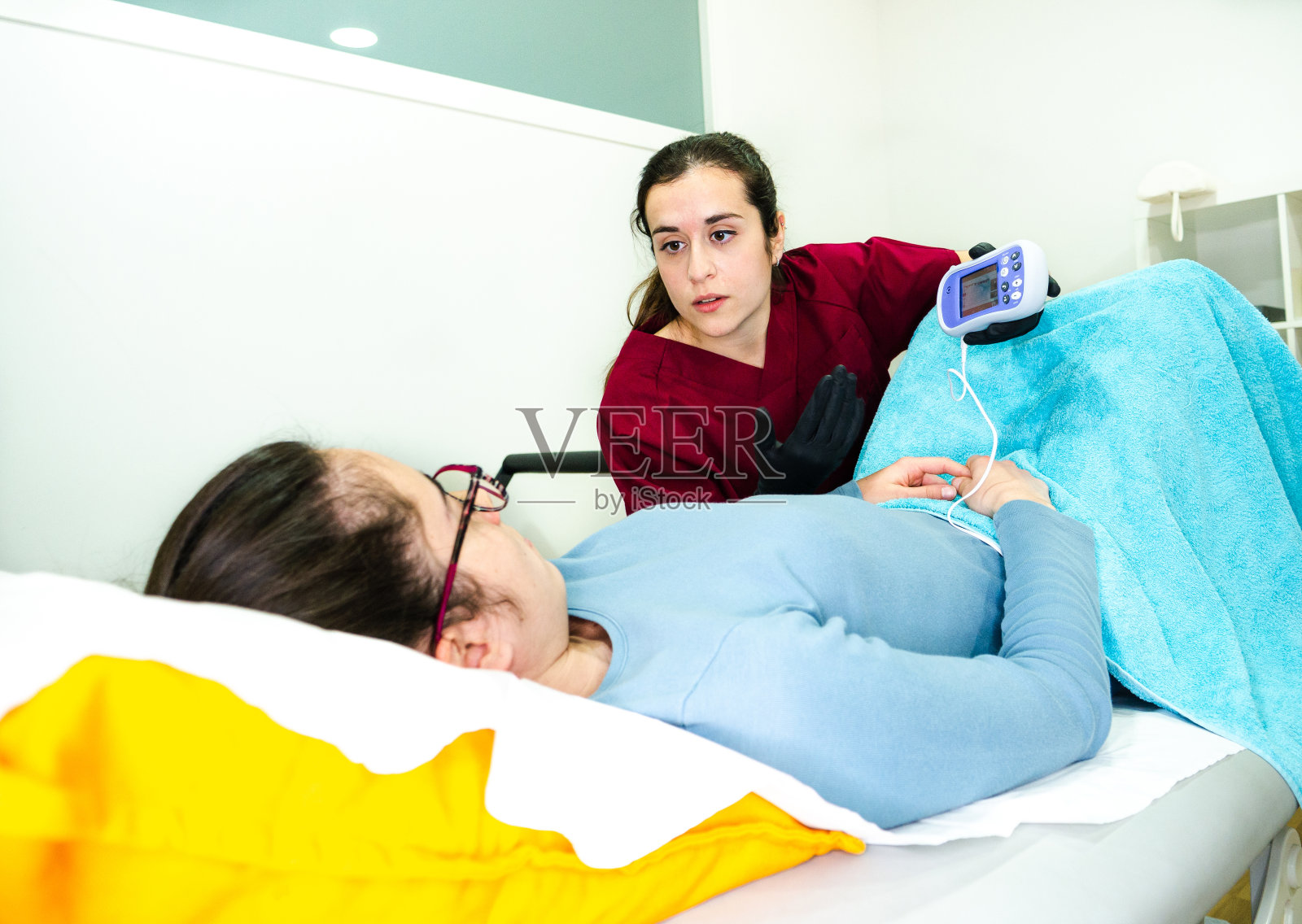 在医生的房间里检查时，妇科医生向妇女展示一些东西照片摄影图片