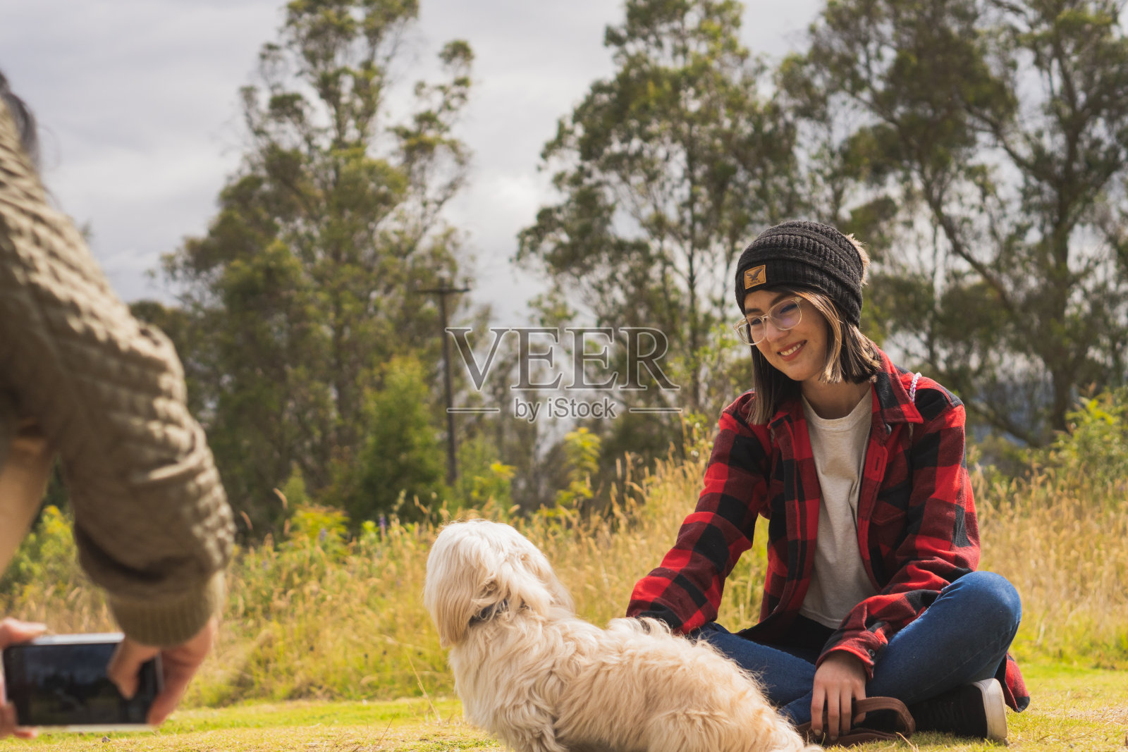 年轻女性带着她们的宠物狗在大自然中散步照片摄影图片