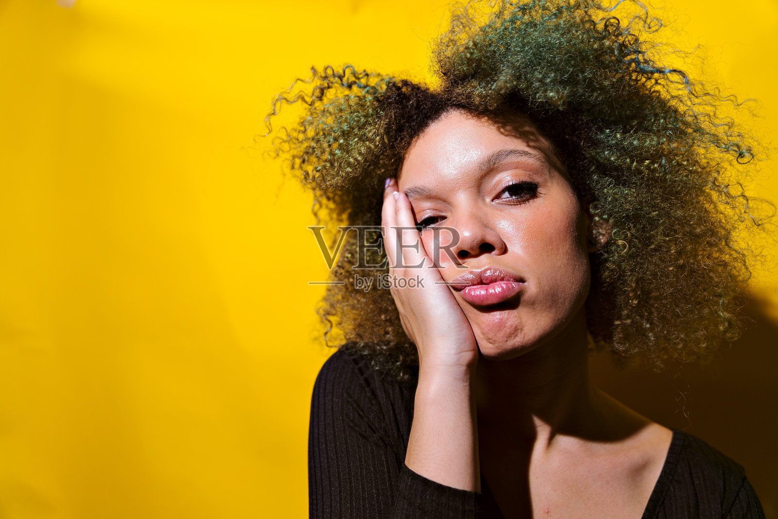 特写镜头的一个非洲裔美国妇女疲惫的表情在黄色的背景照片摄影图片