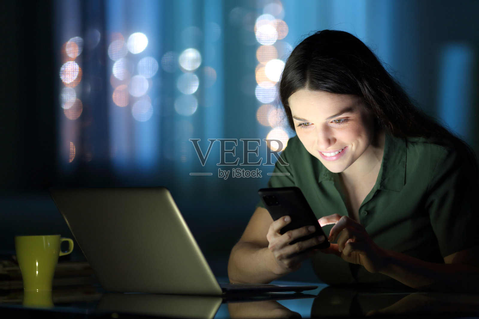 女人在夜里看手机照片摄影图片