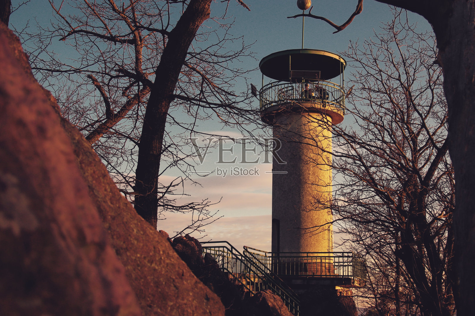 在金色的夕阳下俯瞰瞭望塔，前面是岩石照片摄影图片