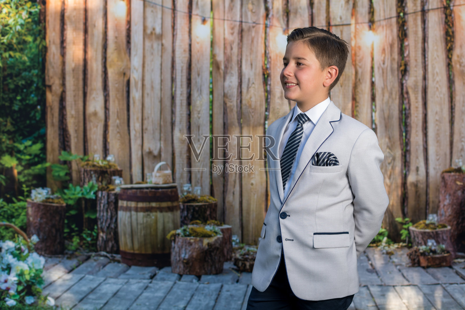 一个小男孩的特写，他穿着浅灰色的运动夹克，打着领带。照片摄影图片