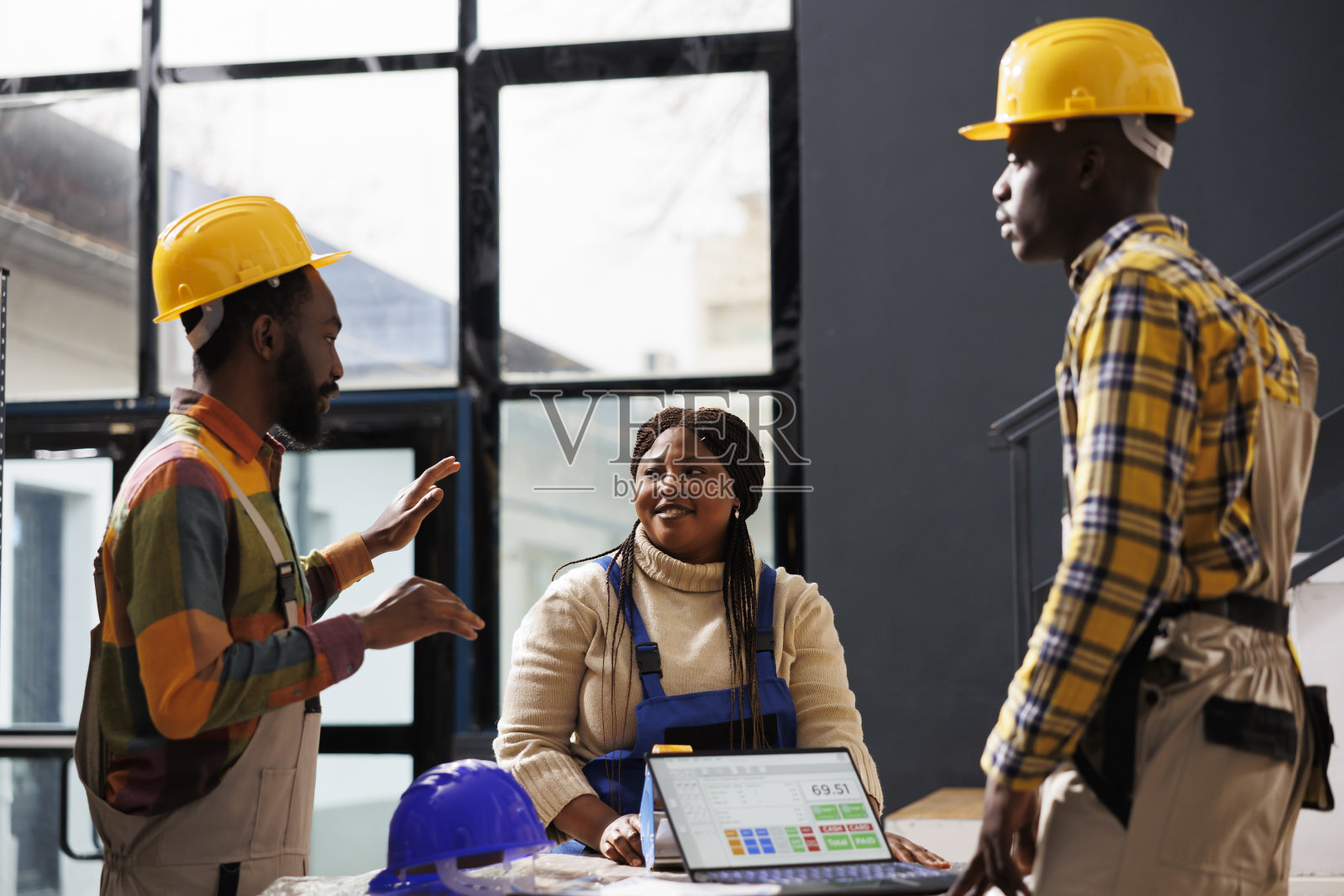 仓库员工在笔记本电脑上检查物品清单并交谈照片摄影图片