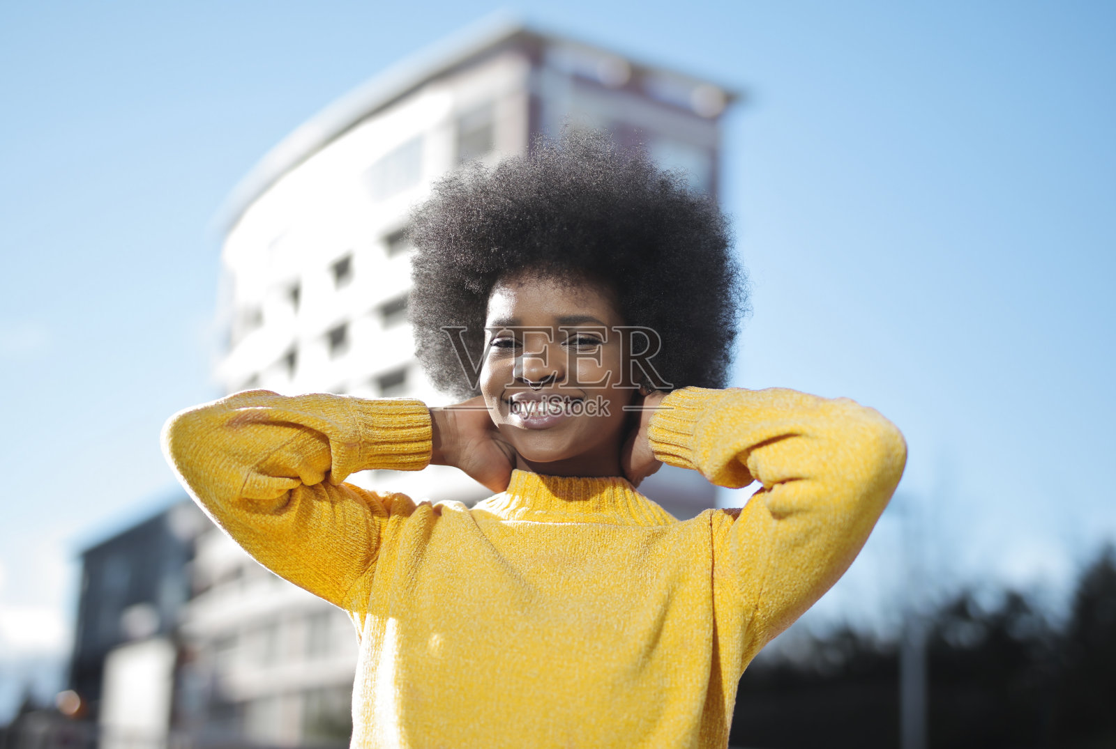 美丽的肖像，一个年轻的黑人妇女在阳光下在街上照片摄影图片