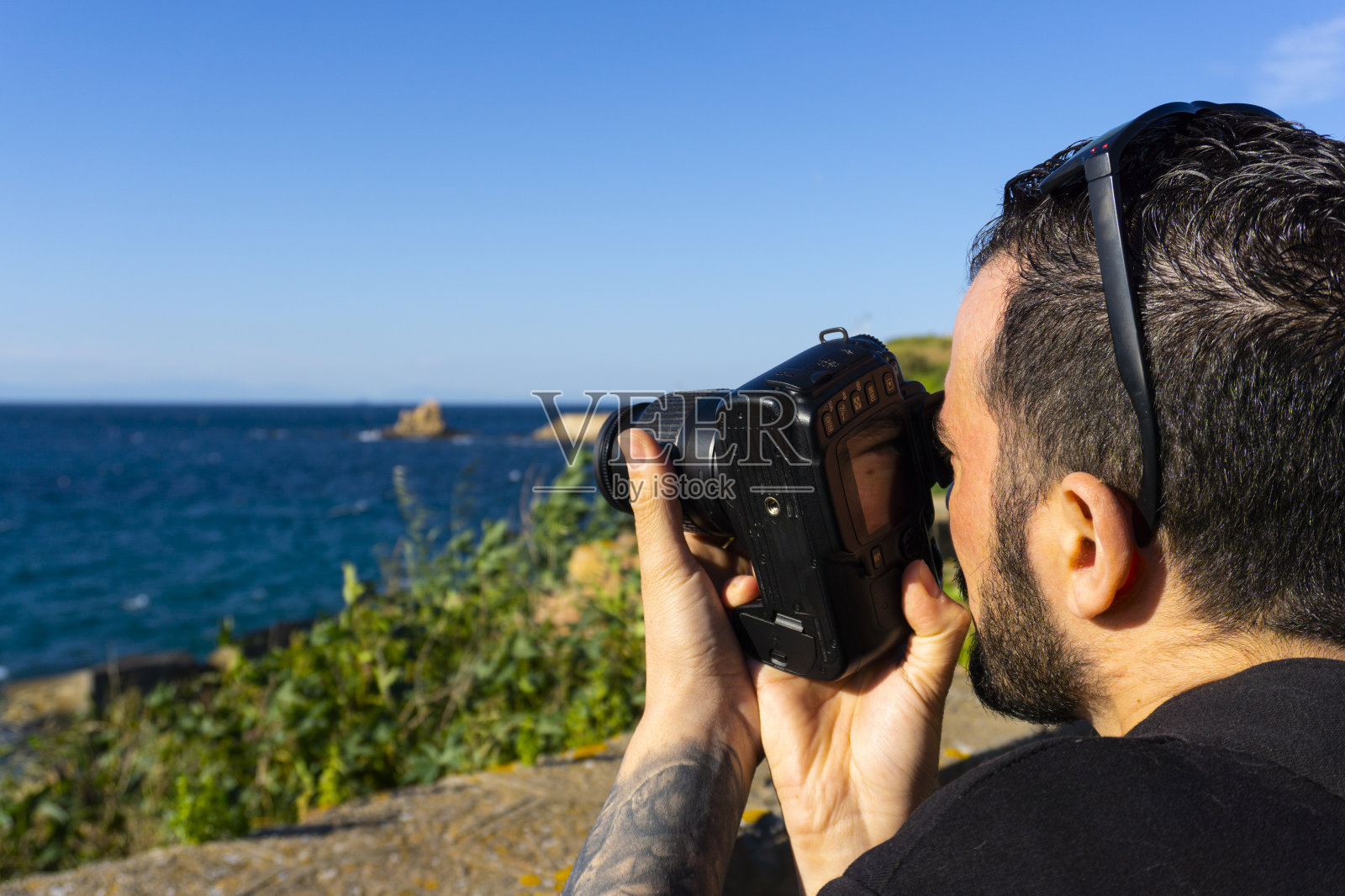 一个白人年轻男性拍摄海景照片的特写镜头照片摄影图片