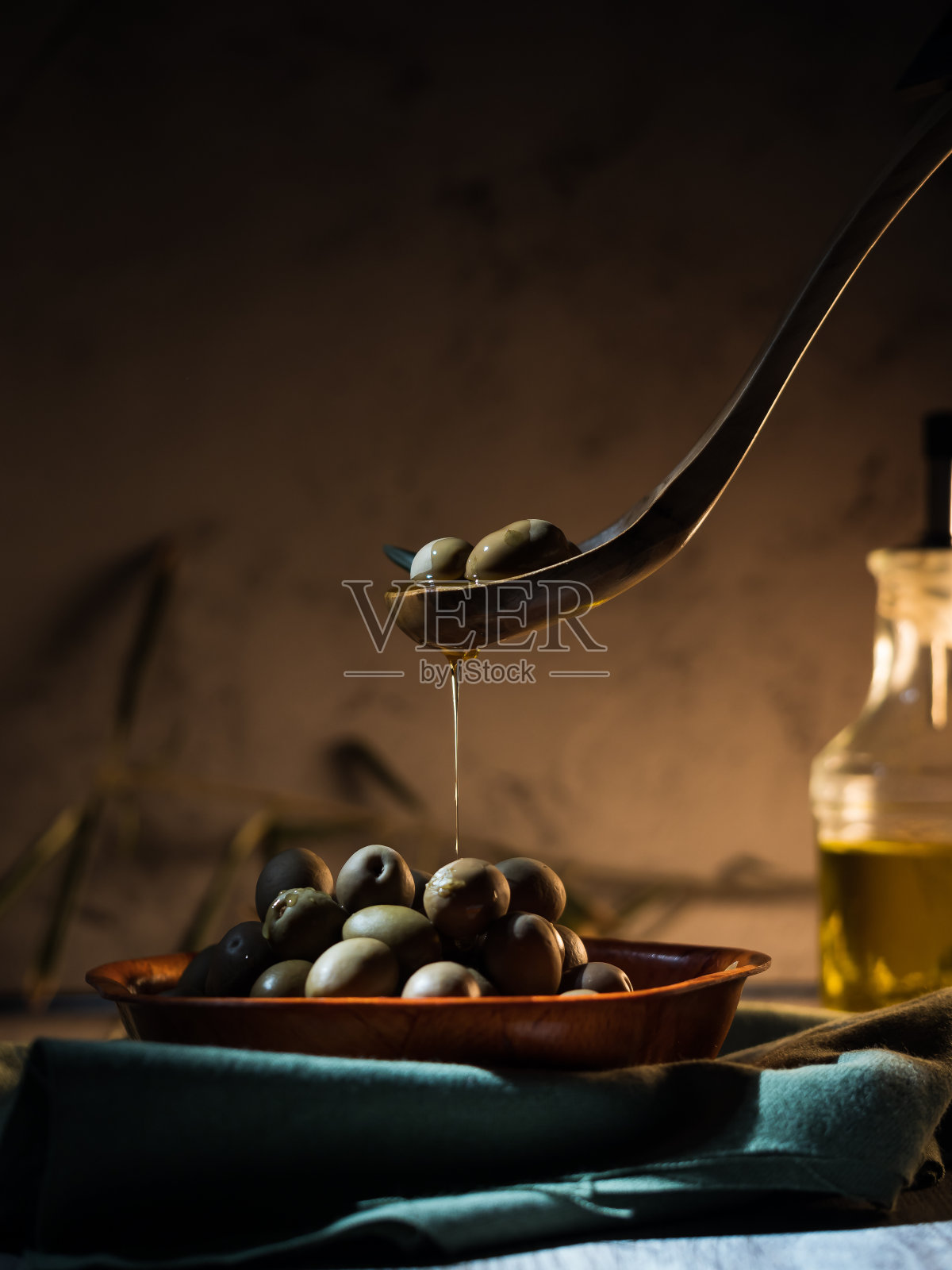 垂直拍摄的橄榄锅与油在厨房照片摄影图片