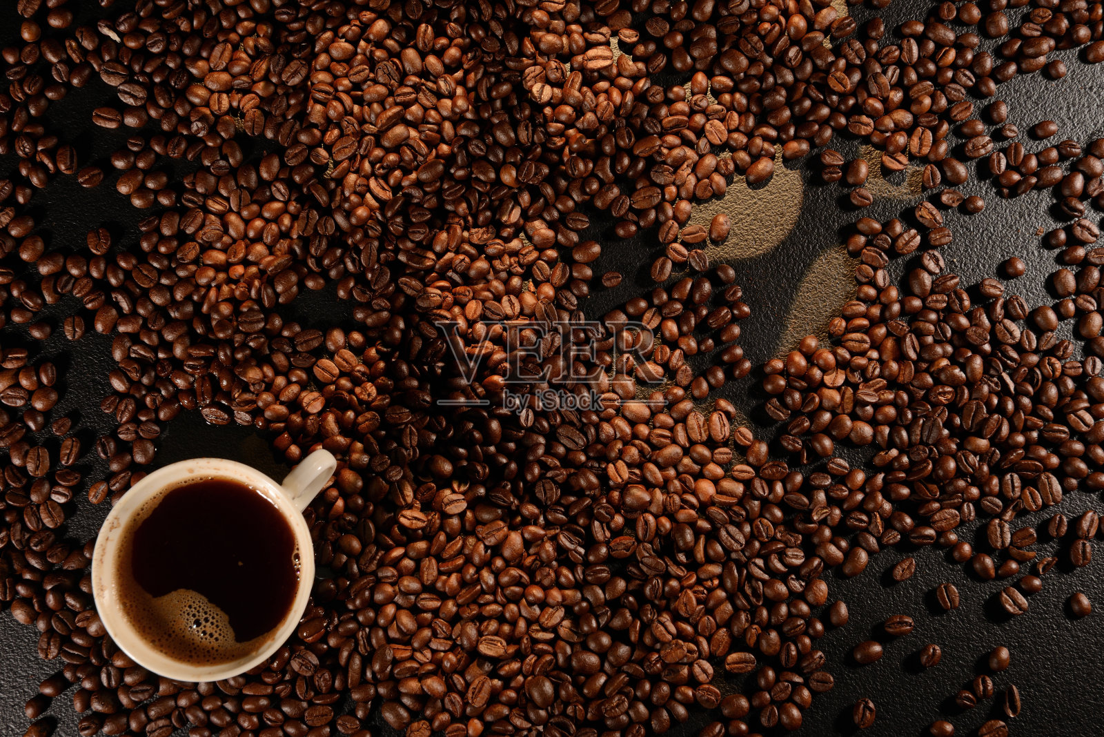 咖啡杯盖过咖啡豆。心的形状照片摄影图片