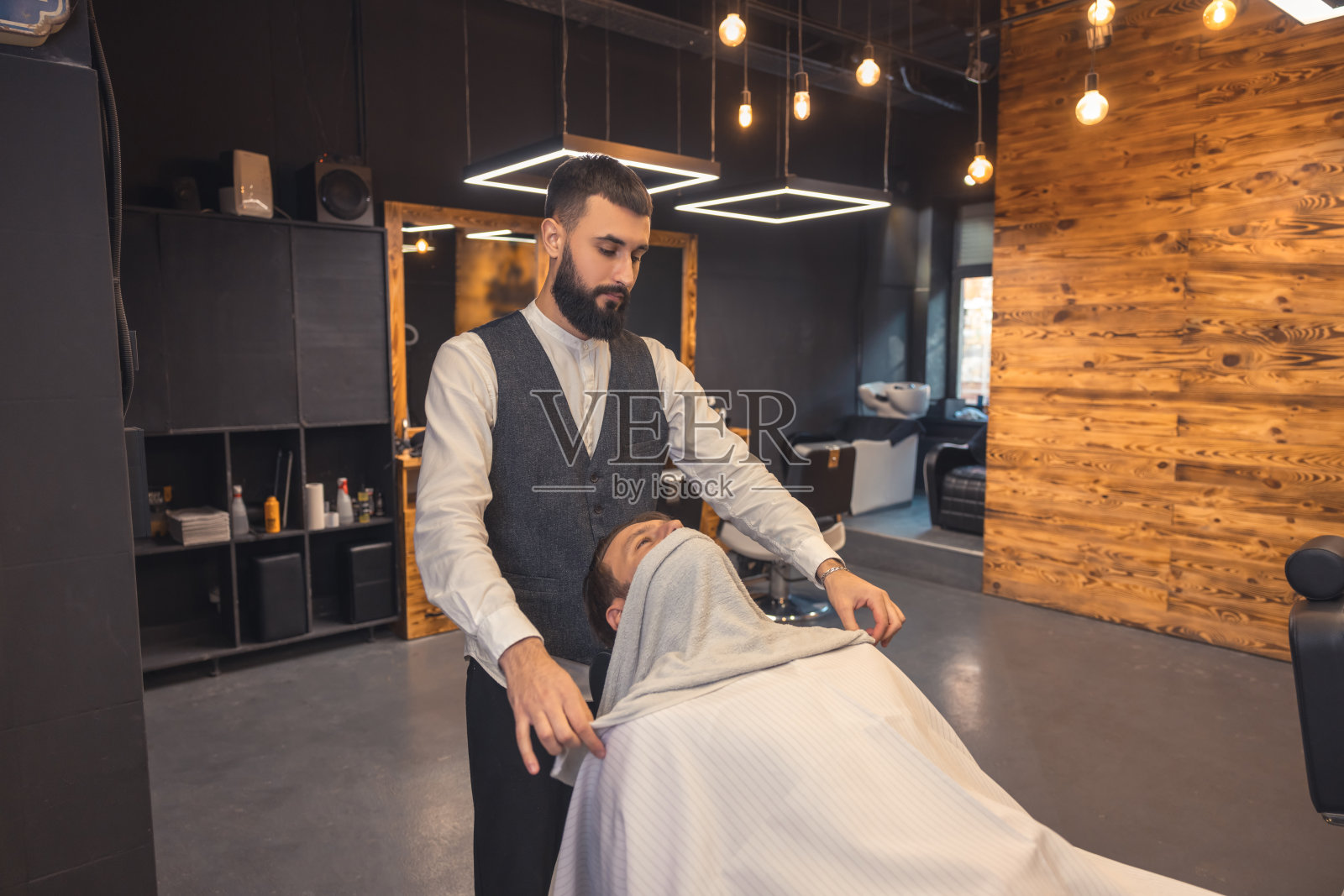 顾客坐在那里，脸上敷着毛巾照片摄影图片