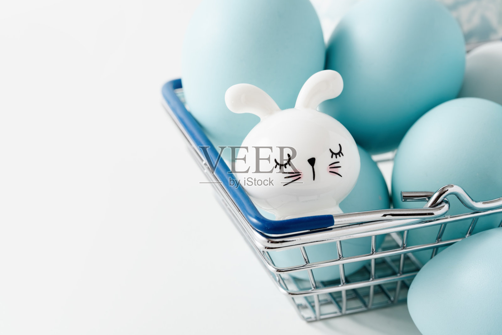 染成蓝色的复活节彩蛋和兔子在篮子里。复活节假期概念。照片摄影图片