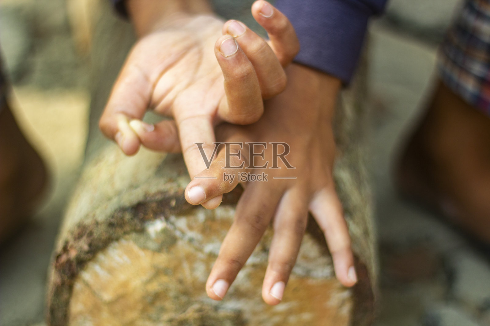 人的手放在树上，背景模糊照片摄影图片