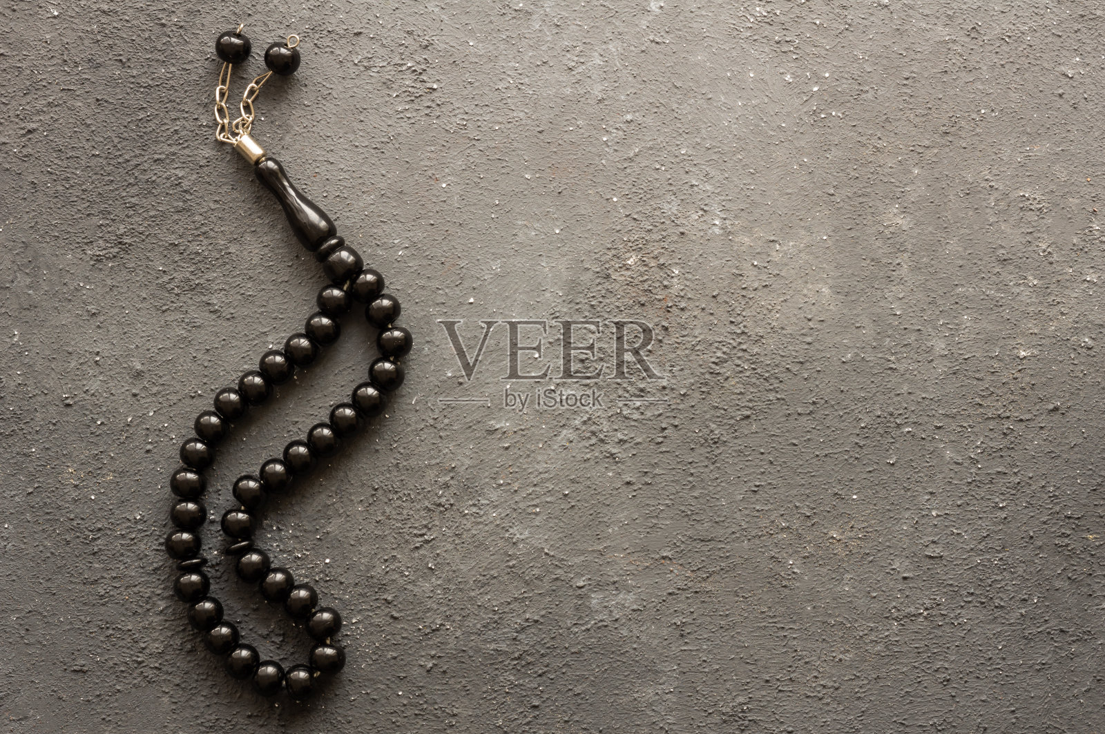 黑色念珠穆斯林祈祷念珠在黑色石头背景，象征伊斯兰教照片摄影图片