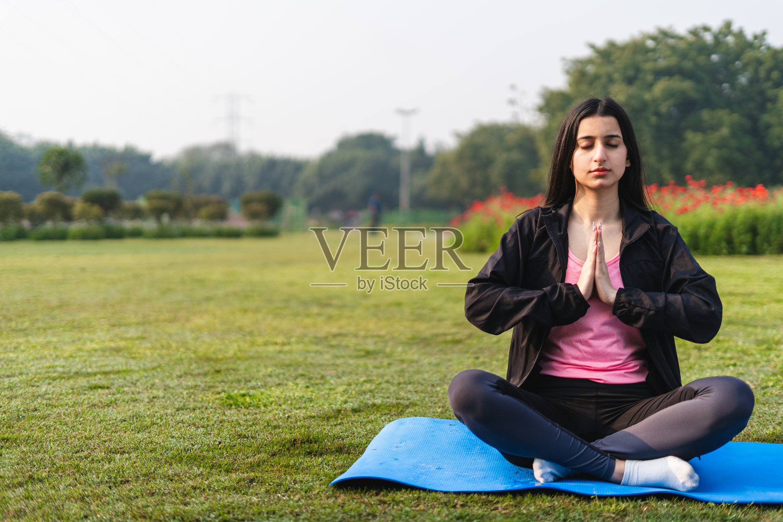 年轻的印度女性在公园做瑜伽和冥想——健康生活方式的概念照片摄影图片