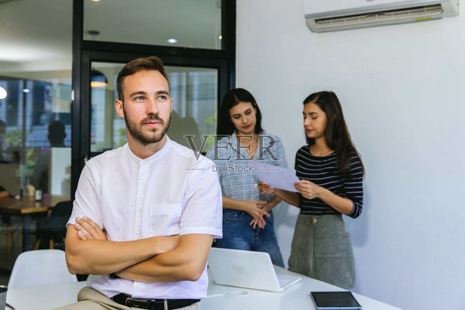 英俊的商人在明亮的现代办公室的笔记本电脑上工作照片摄影图片