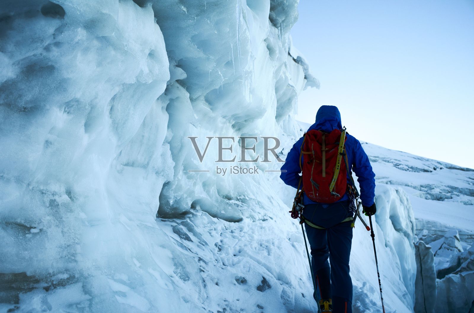 徒步旅行者在白天用特殊装备和背包攀登雪山照片摄影图片