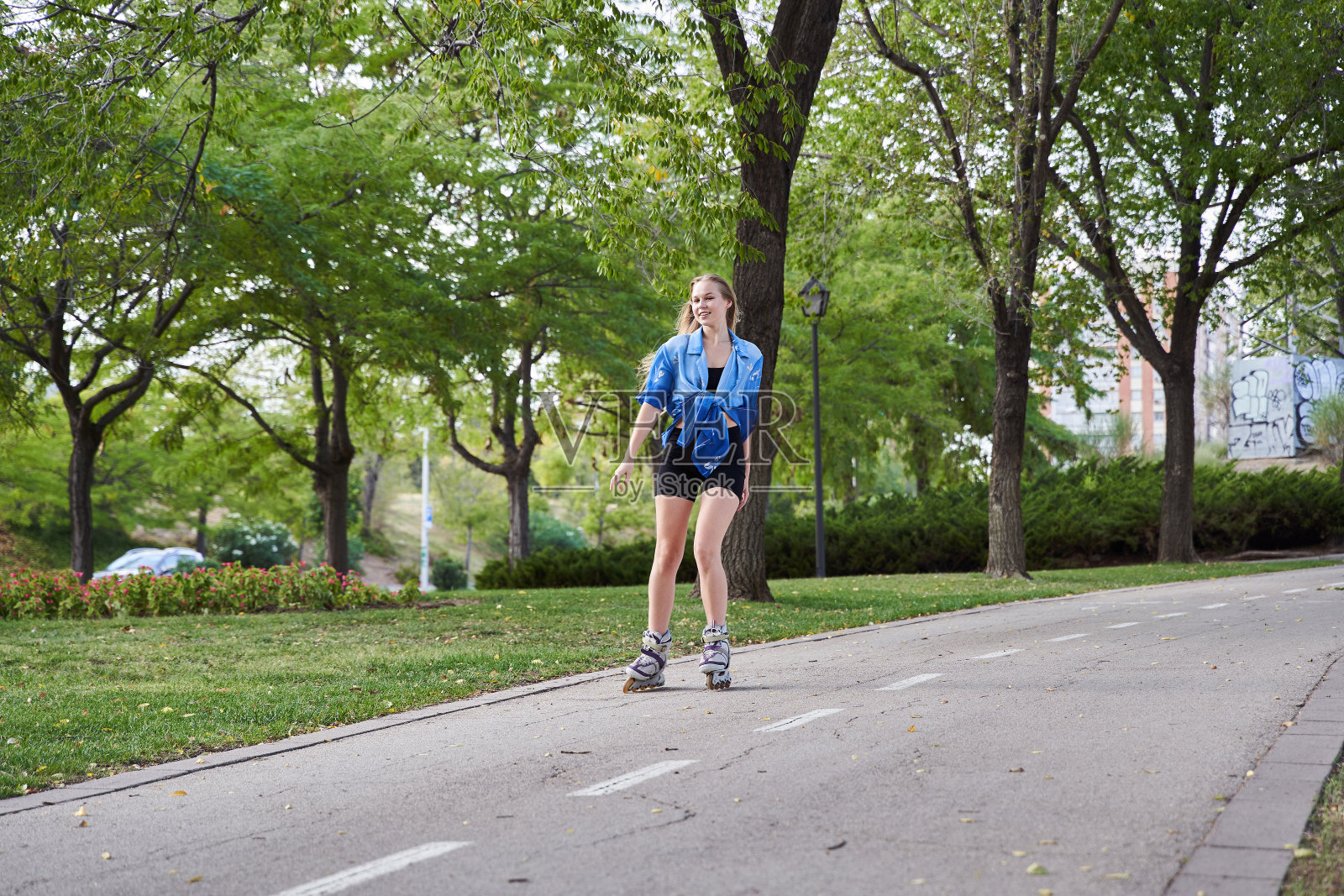 金发女人用直排旱冰鞋滑板照片摄影图片