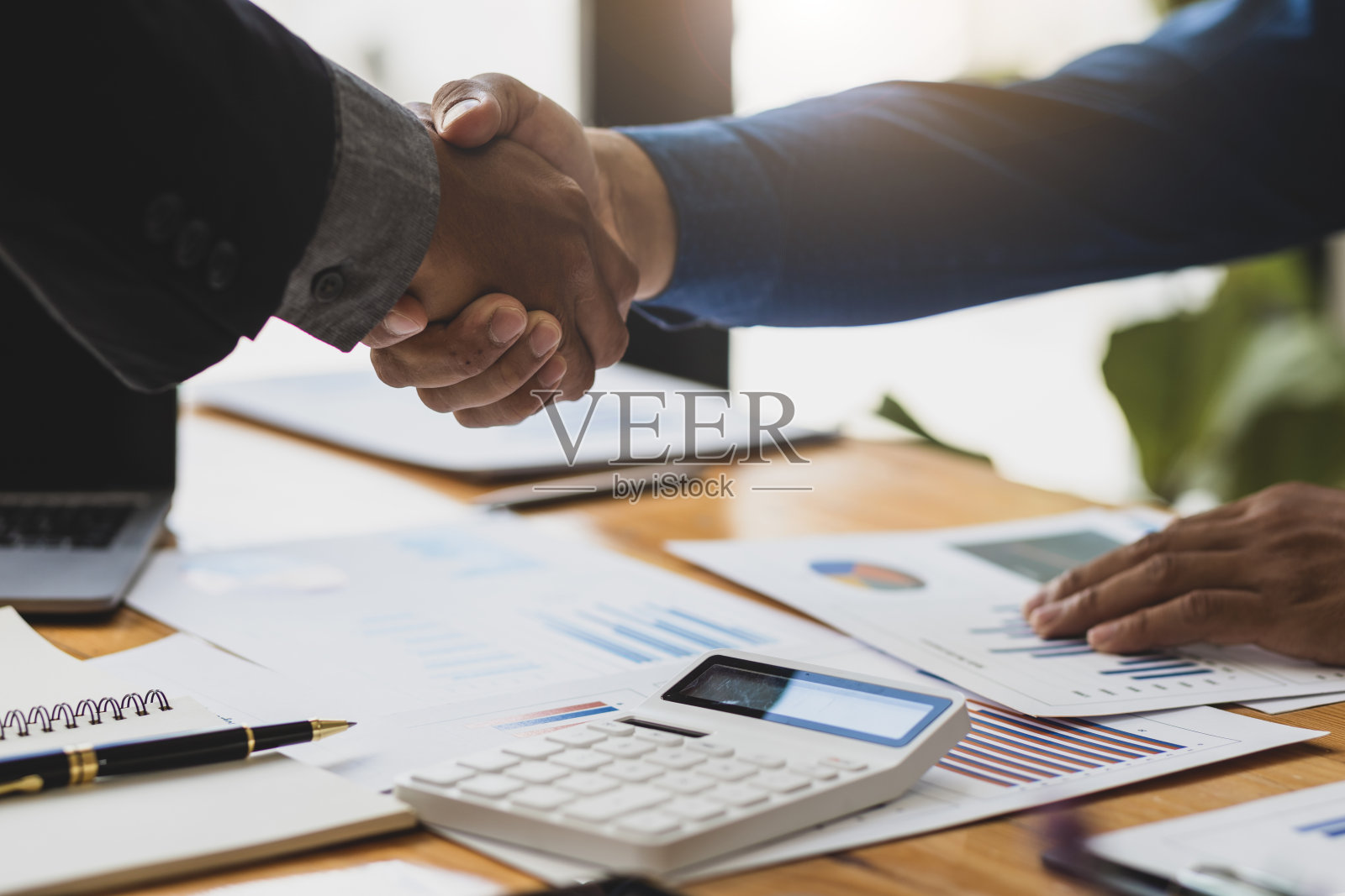 握手，业务伙伴和财务顾问的合作，以计划投资。照片摄影图片