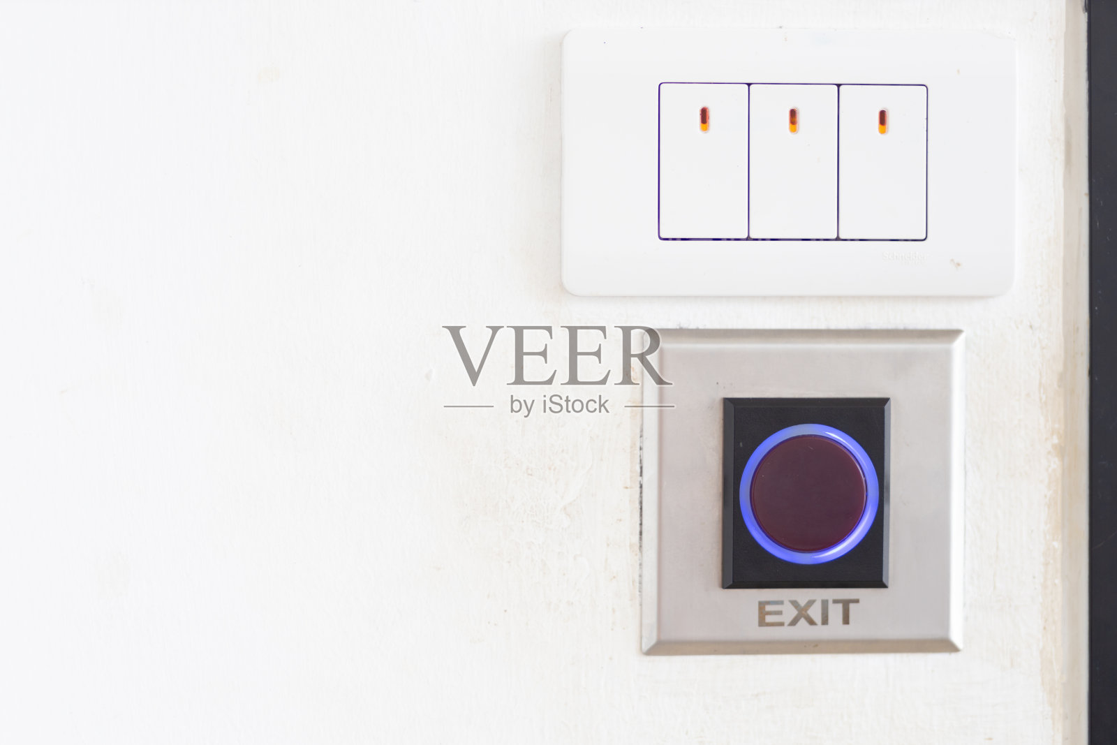 关上门旁边墙上的电灯开关和退出按钮。照片摄影图片