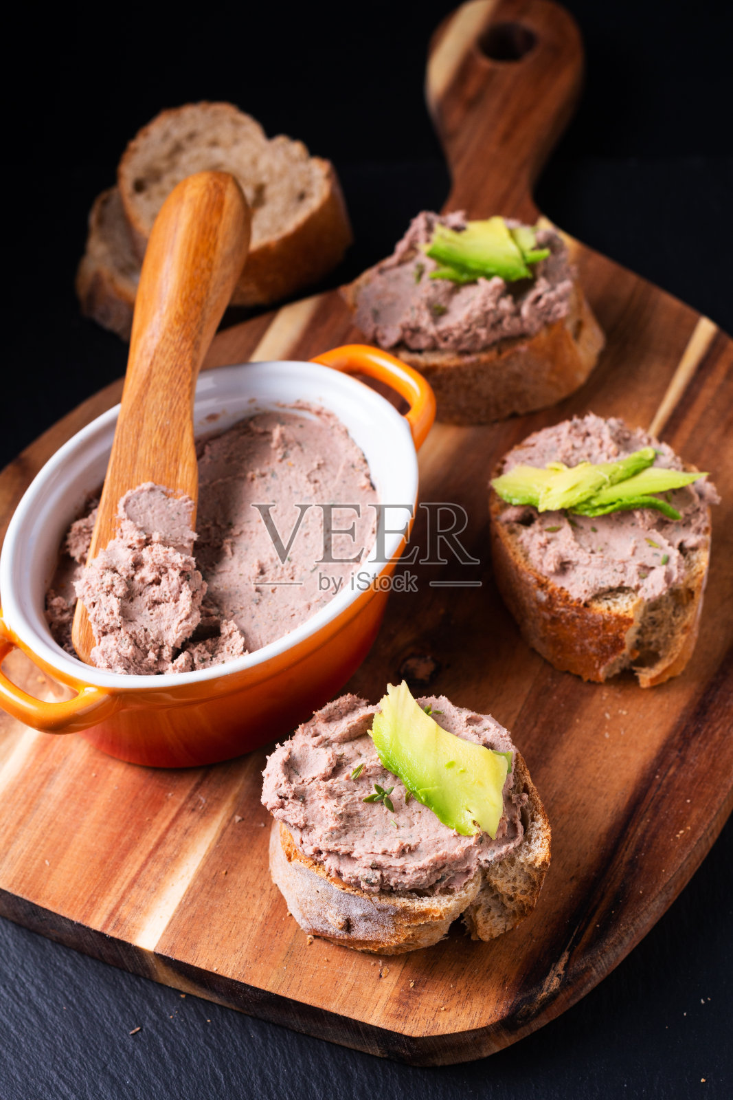 食物概念鸡肝散布馅饼法棍咬木板上黑色背景与复制空间照片摄影图片