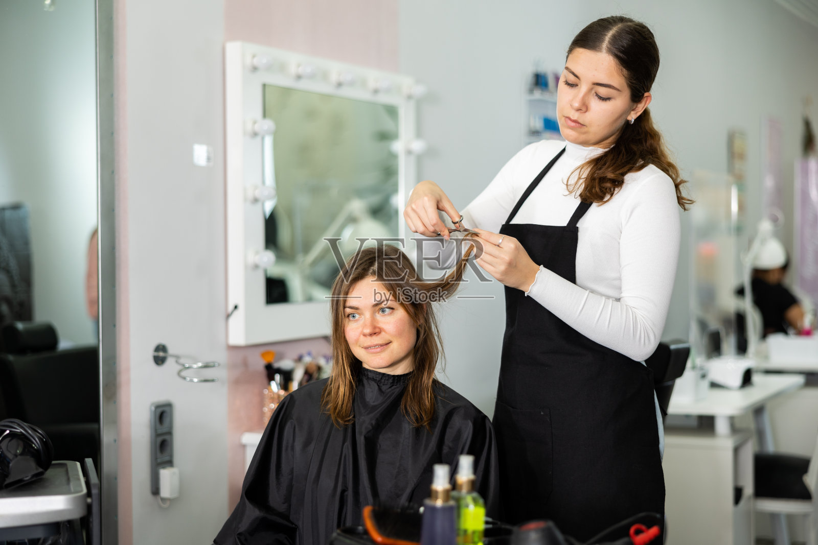 年轻女性发型师为女性客户理发照片摄影图片