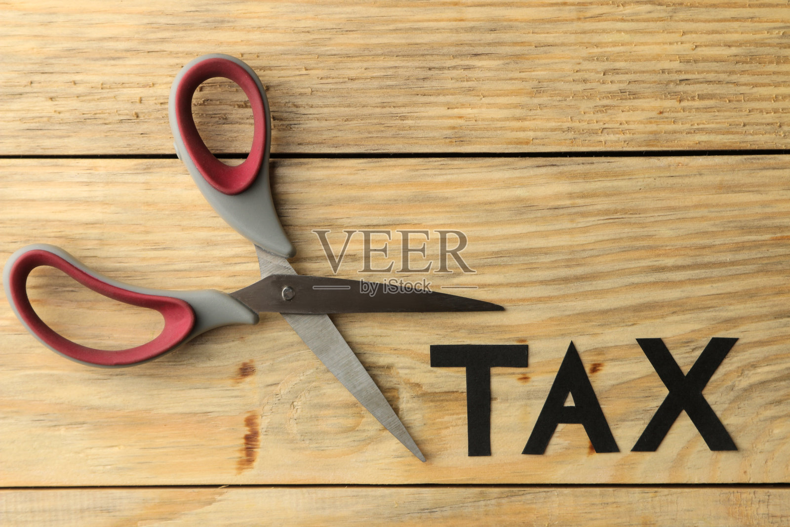 “税”和“剪刀”两个字放在一张天然木桌上。税收俯视图照片摄影图片