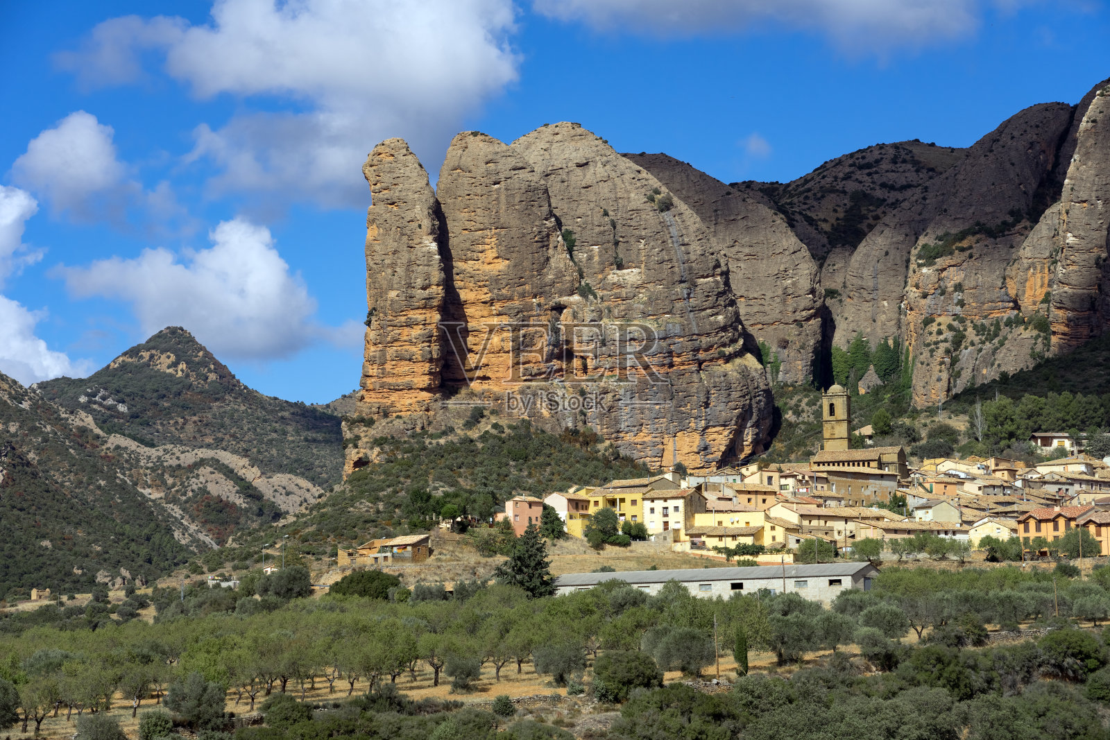 Famous climb walls mountains of Mallos de Agüero (Aguero cliffs) in Huesca and the Agüero village in the foreground.照片摄影图片