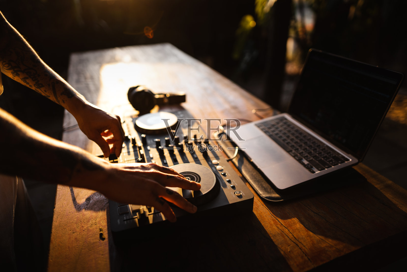 DJ在播放音乐，男人在晚上的聚会上使用调音台照片摄影图片