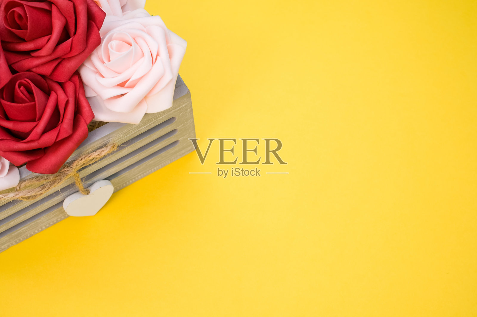 红色和白色的玫瑰放在一个盒子里，黄色背景照片摄影图片